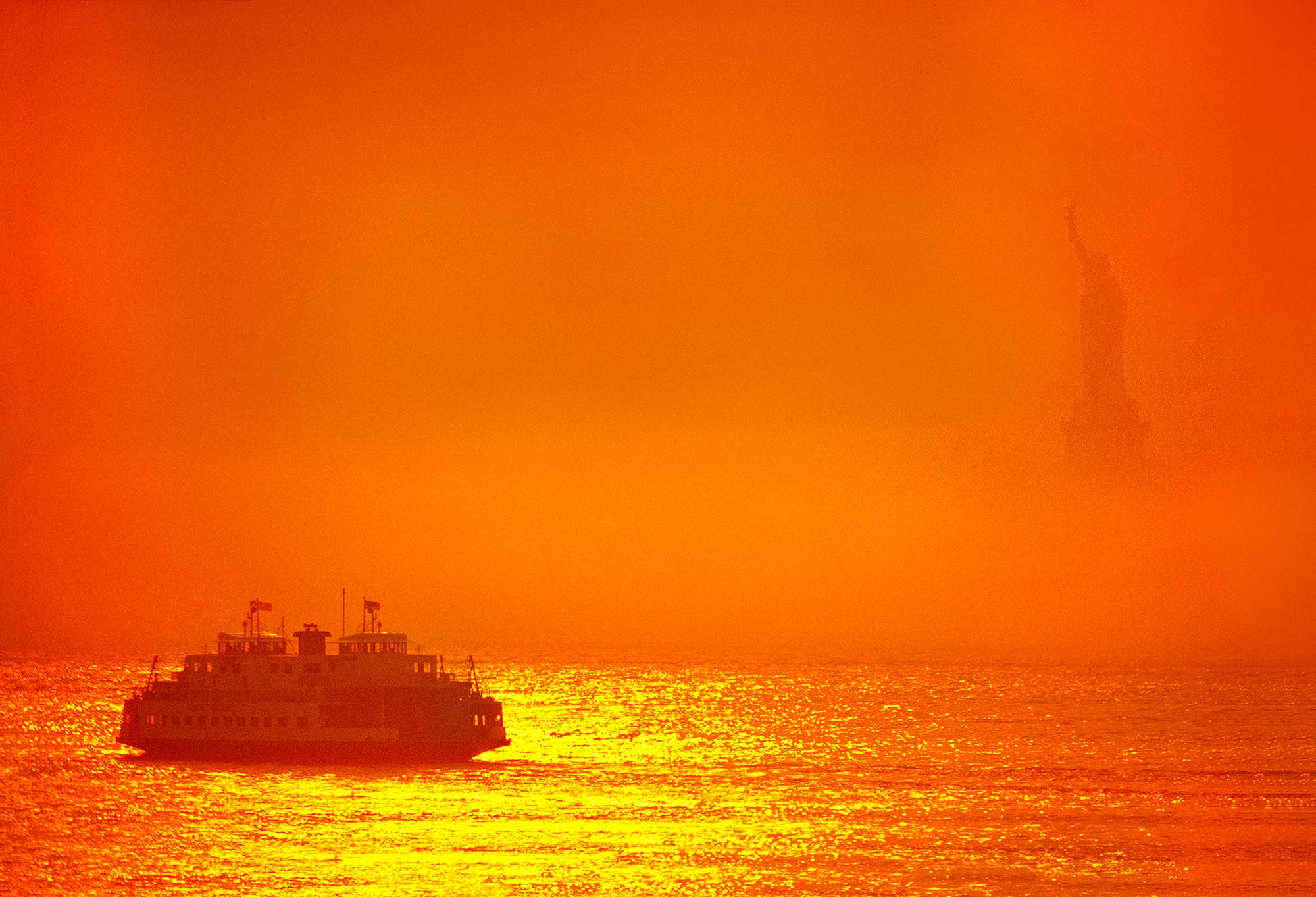 Mitchell Funk Color Photograph – Staten Island Ferry im New Yorker Hafen mit orangefarbenem Licht auf der Freiheitsstatue 