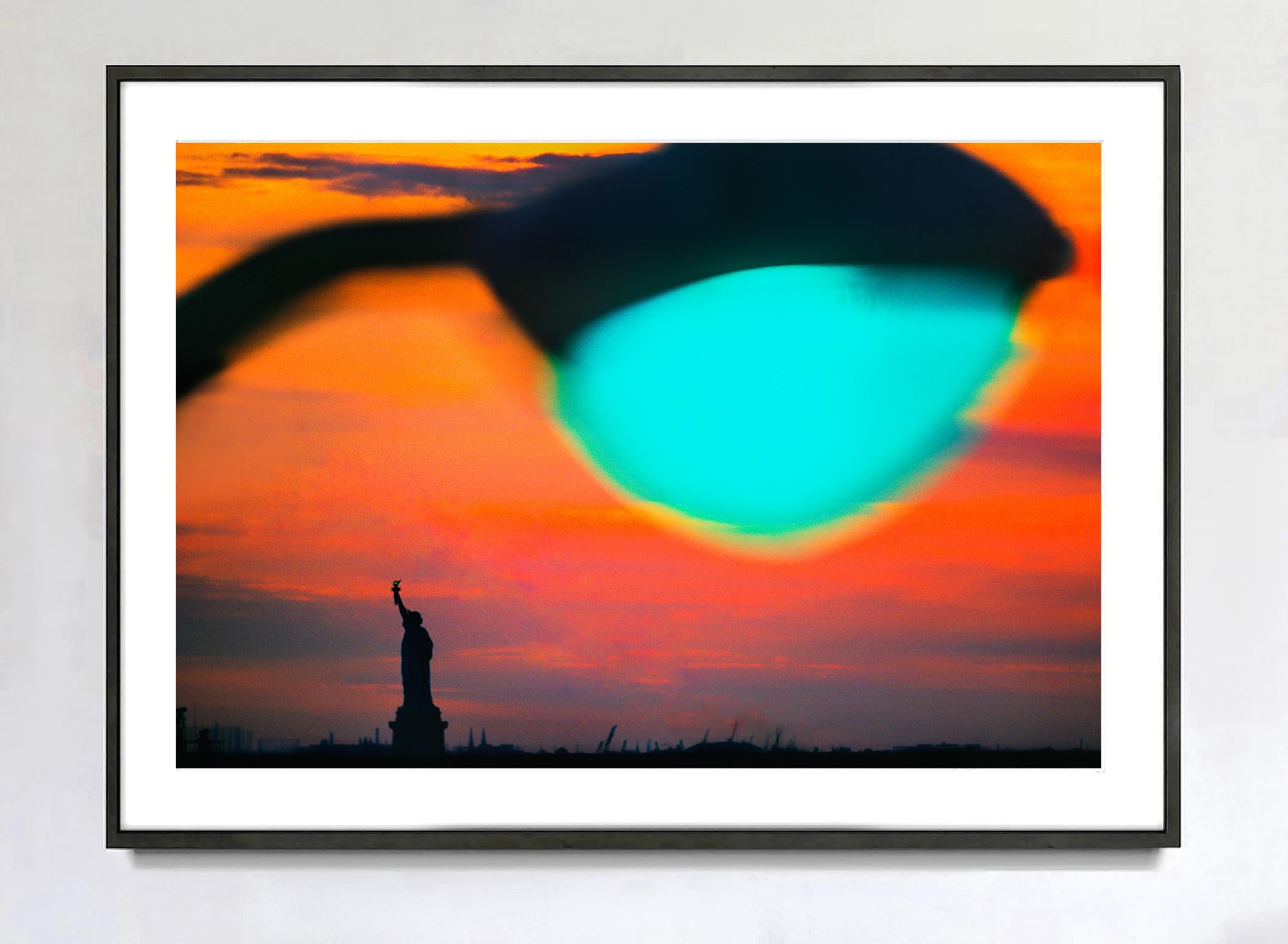 Statue der Freiheitsstatue des New Yorker Hafens bei Sonnenuntergang mit grünem Licht – Photograph von Mitchell Funk