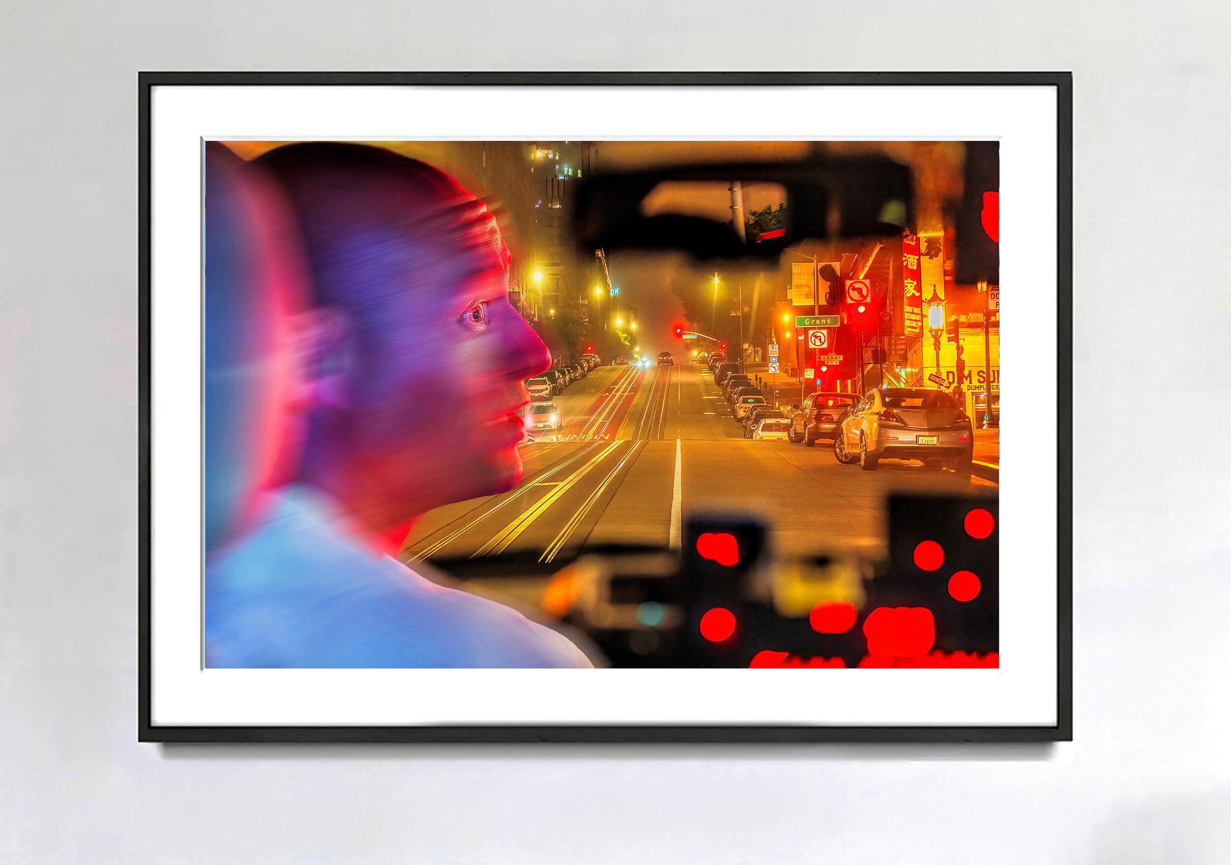 Una vista inaspettata delle strade di San Francisco di notte  è stata immortalata dal fotografo di strada Mitchell Funk.  Dall'interno di un taxi, vediamo il conducente di profilo mentre gira la testa. Il suo occhio è affilato, mentre il resto della