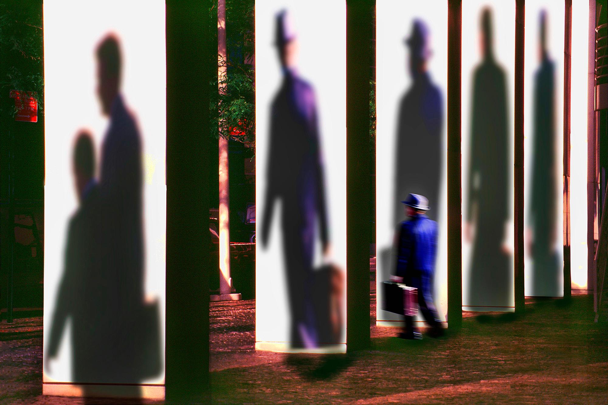 Figurative Photograph di Mitchell Funk - Scena surreale di città con uomo e le sue ombre a Manhattan