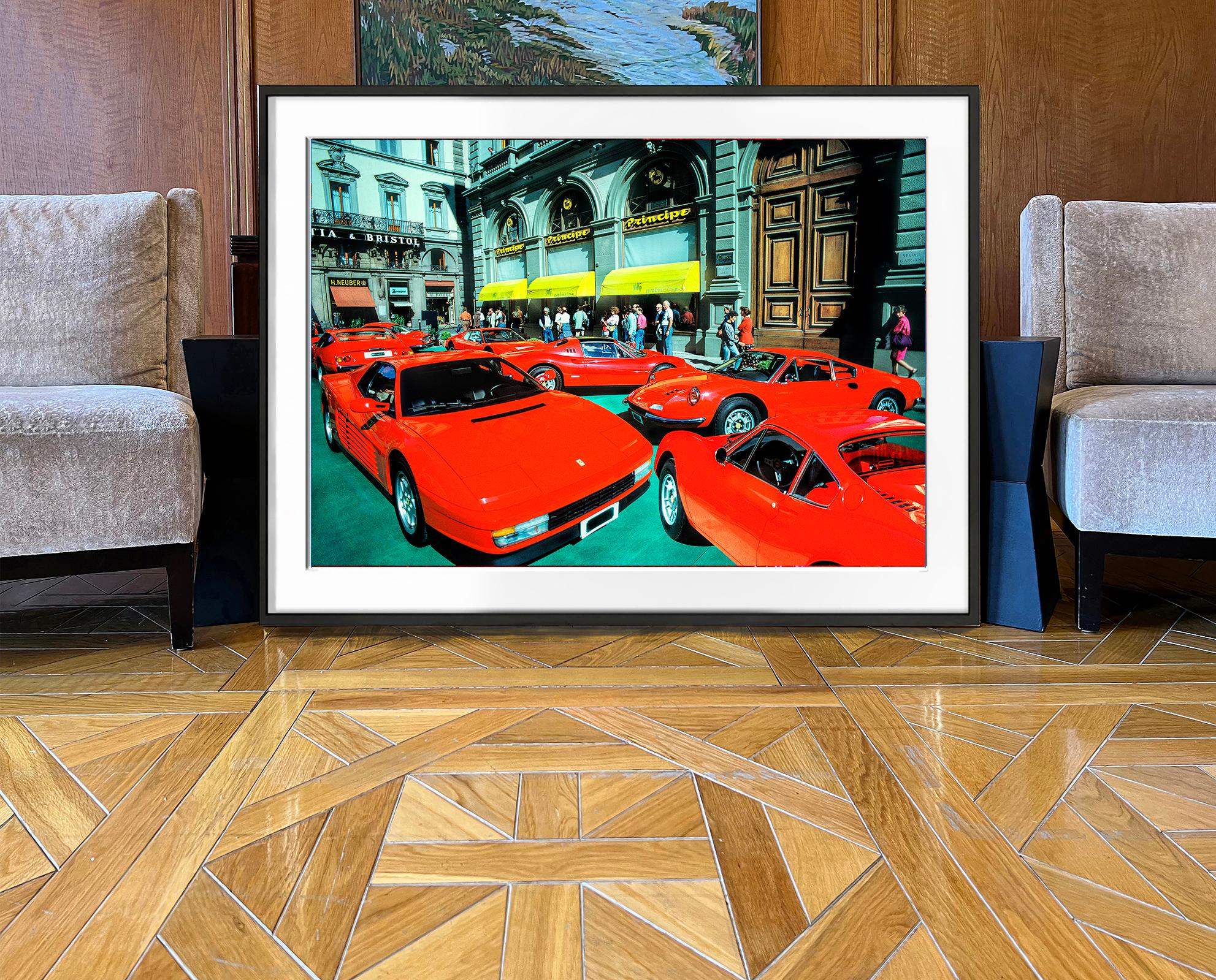 Une grappe de Ferrari rouges d'époque est exposée sur une place de Florence, en Italie.  Le photographe de rue Mitchell Funk a été frappé par ce site inattendu et a documenté la scène en mettant l'accent sur sa nature graphique et sa couleur rouge