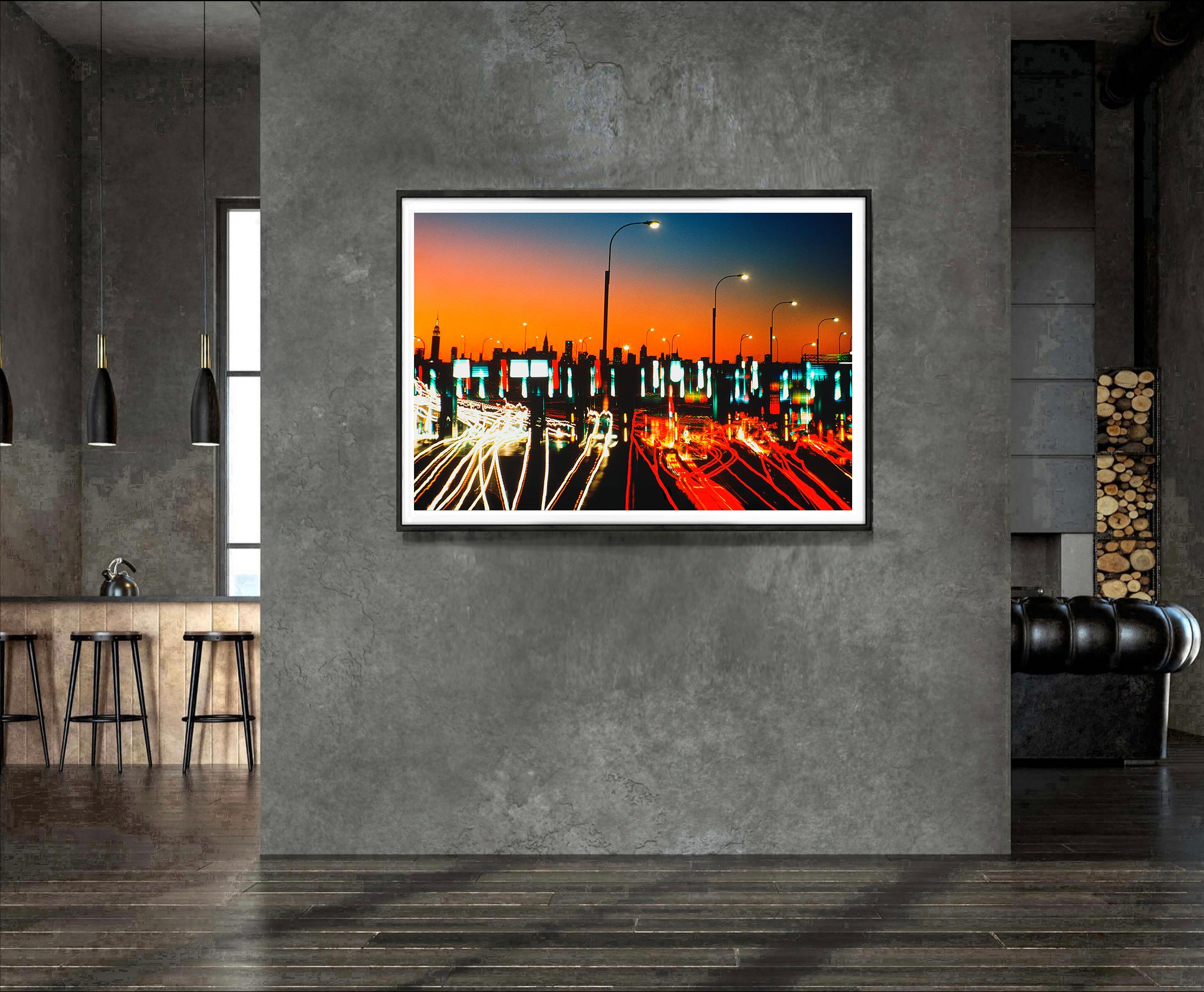 Photographer Mitchell Funk creates a dialogue between New York City's traffic and its architecture. In the present work, Funk fills the foreground with a frenetic pattern of car lights as they enter the Midtown Tunnel. The car lights feature a