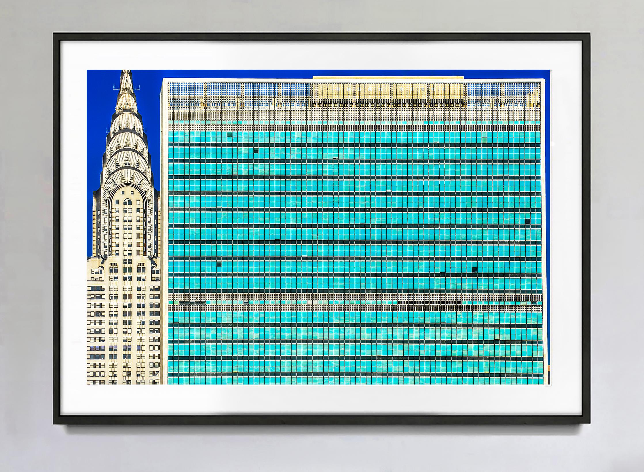 Taken from Long Island City, this tightly cropped composition emphasizes bold silhouettes while revealing the interplay of two of New York City's most iconic buildings. The horizontal grid-shaped turquoise blue facade of the United Nations