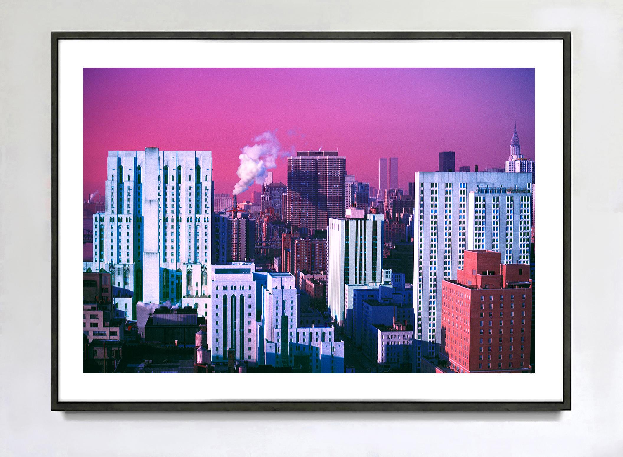 En lo alto de un rascacielos de la Avenida York, el fotógrafo Mitchell Funk capta una vista invernal de Manhattan a primera hora de la mañana. 
A la derecha de una gran bocanada de humo y a la derecha de las Torres Gemelas, encontrarás el Edificio