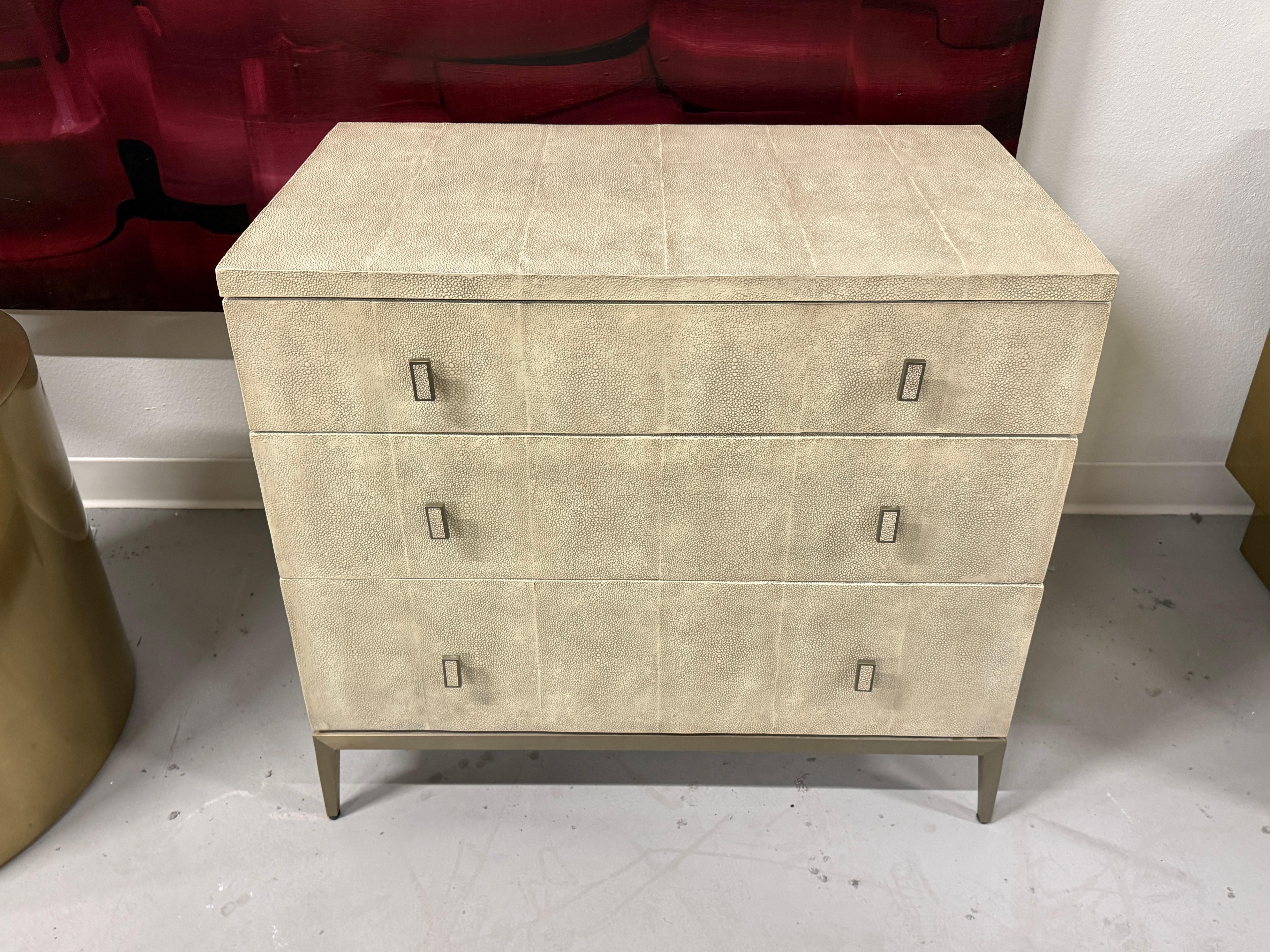 Un'incantevole cassapanca rivestita in pelle con finitura colorata e ciottolata color zigrino. Credo che il metallo sia il bronzo. La cassa è di Mitchell Gold + Bob Williams della serie Solange.  presenta gli interni dei cassetti dipinti di rosso.