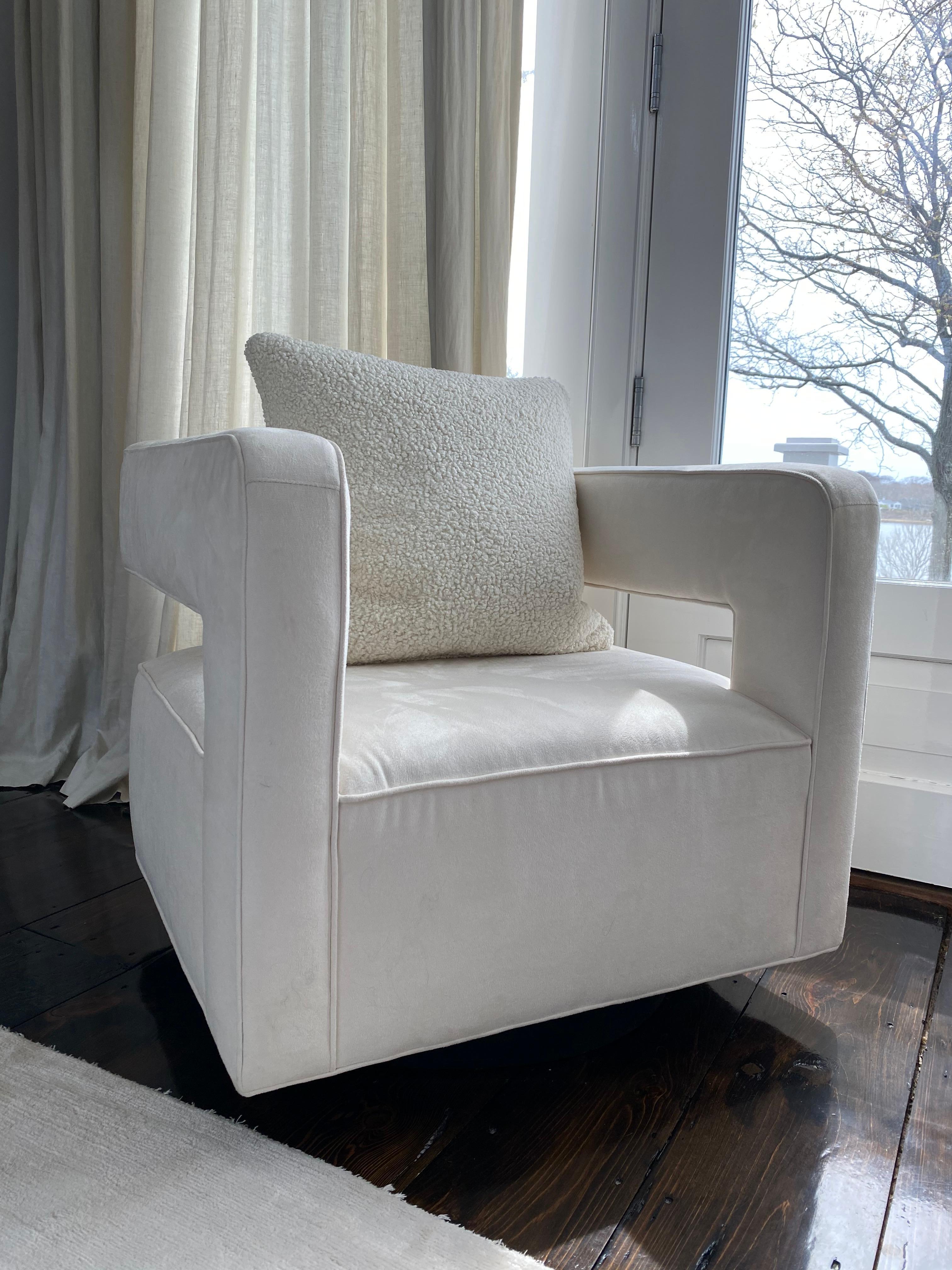 Pair of Nico chairs by Mitchell Gold and Bob Williams in white cream ultrasuede. 

Floating shelter backrest and square arms on a round wood swivel base. 

Slight blemishes from use.