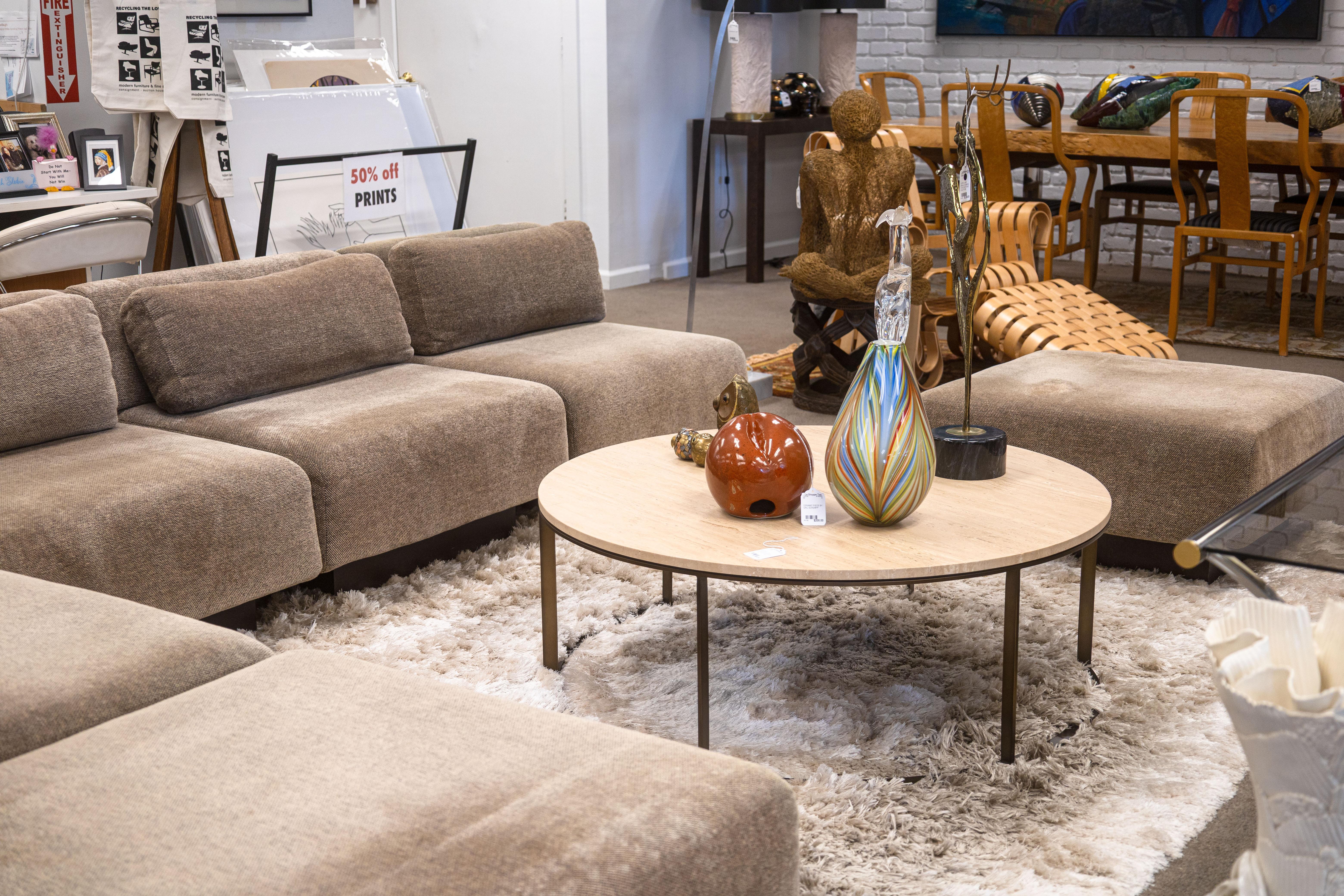 A Mitchell Gold + Bob Williams round travertine coffee table. This lovely contemporary coffee table features a large, round design, perfect for a large living room space. It has a beautiful, thick piece of travertine stone as a table top. The