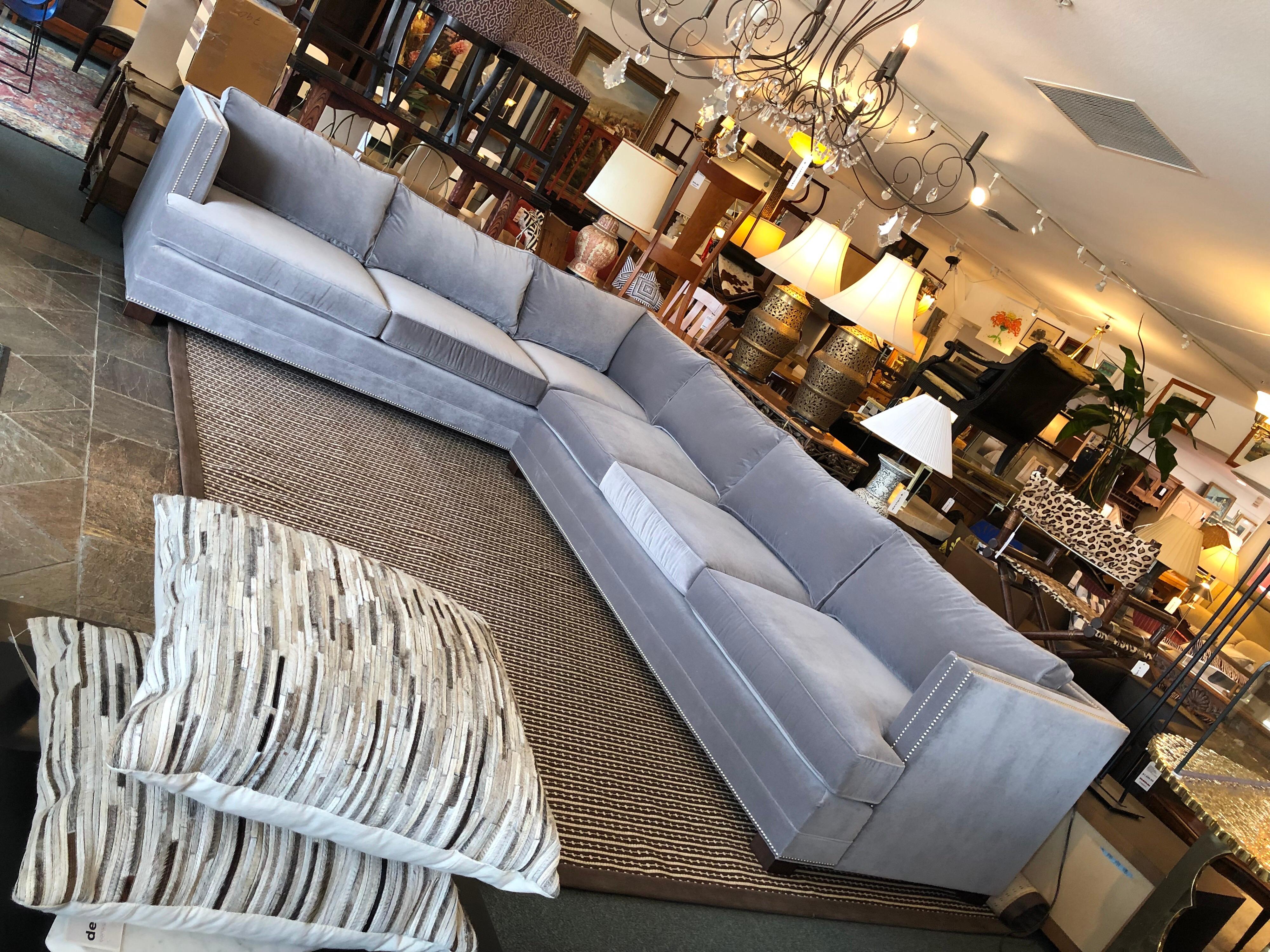 A large, elegant sectional from Mitchell Gold. Stretch out on luxurious velvety gray fabric, detailed with chrome nailhead and dark stained, removable legs. Inside the two sections, you will find an eco-friendly hardwood frame, high density,