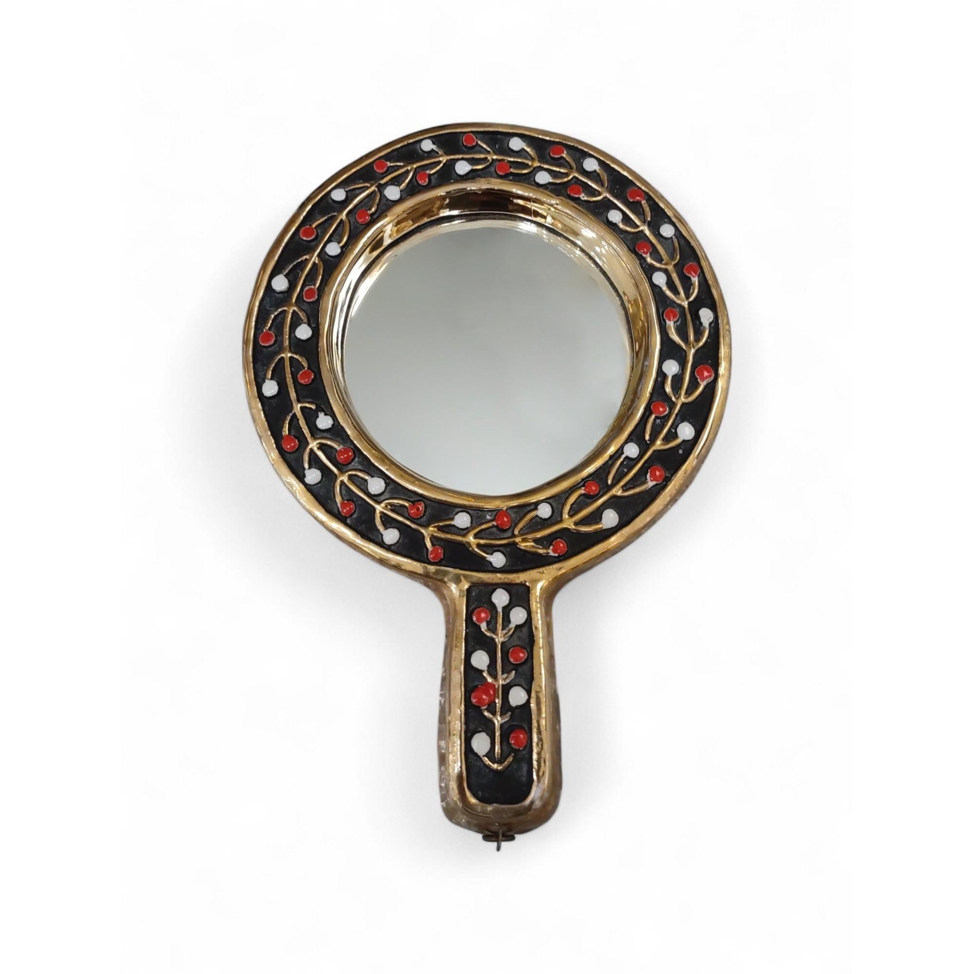 A rare and exquisite “Guirlande” hand mirror by celebrated French designer Mithé Espelt (1923–2020), renowned for her poetic and modern approach to decorative arts. Crafted in the 1950s, this piece combines gilded ceramic with vibrant red and white