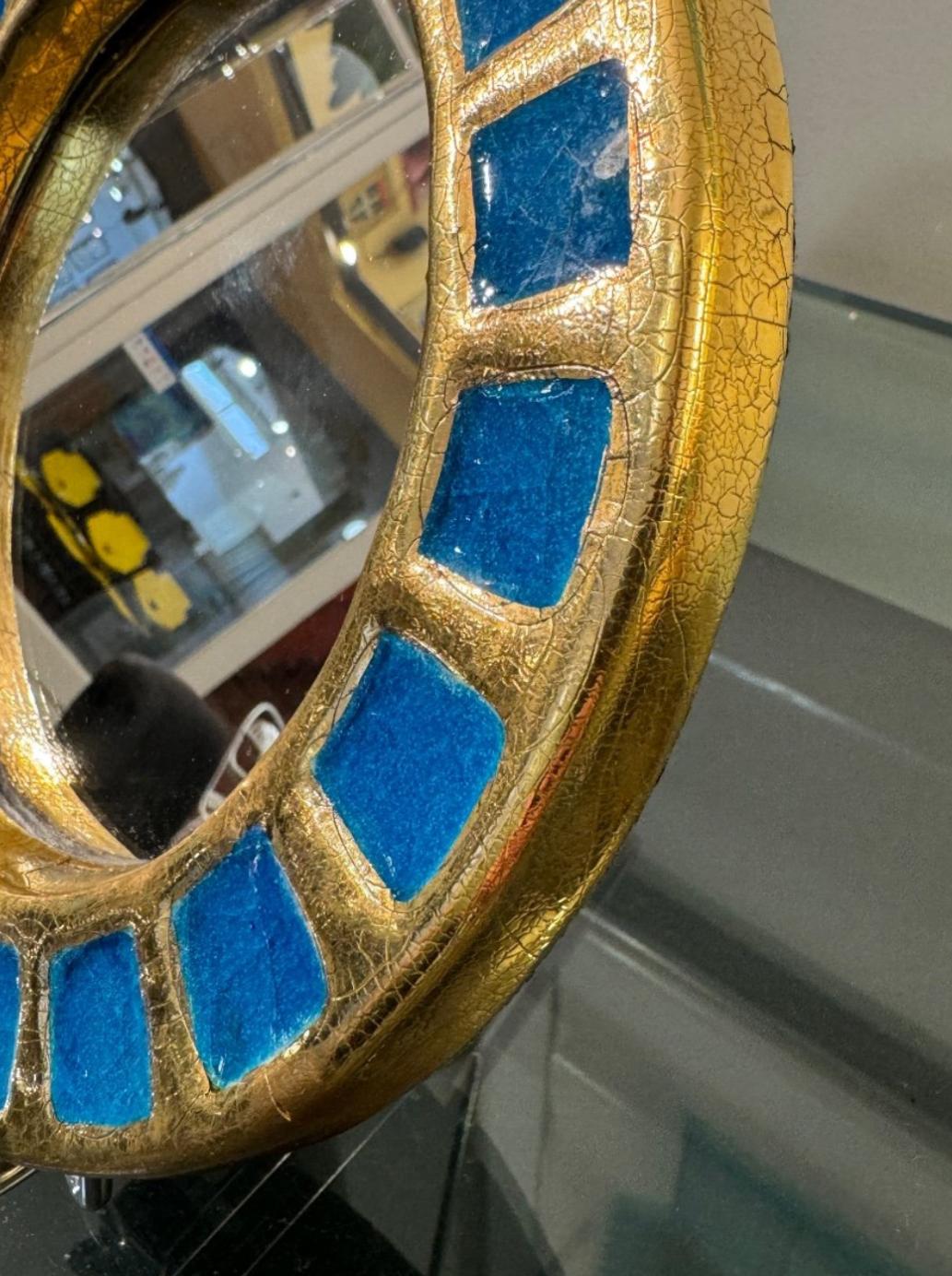 Mithé ESPELT (1923-2020) Soleil bleu MIROIR. Épreuve circulaire en céramique émaillée or à fond craquelé et à décor de vingt carreaux d'email bleu turquoise en réserve. Le revers gagné de feutrine verte. Diam. 22 cm Bibliographie : Antoine Candau