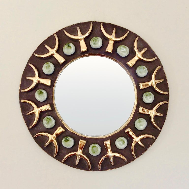 Beautiful Mithe Espelt round wall mirror, circa 1970, France.
Black ceramic with gold, white and green enameled decor.
Dimensions: 23 cm diameter, 2 cm D.
Original vintage item in good condition.
All purchases are covered by our Buyer Protection