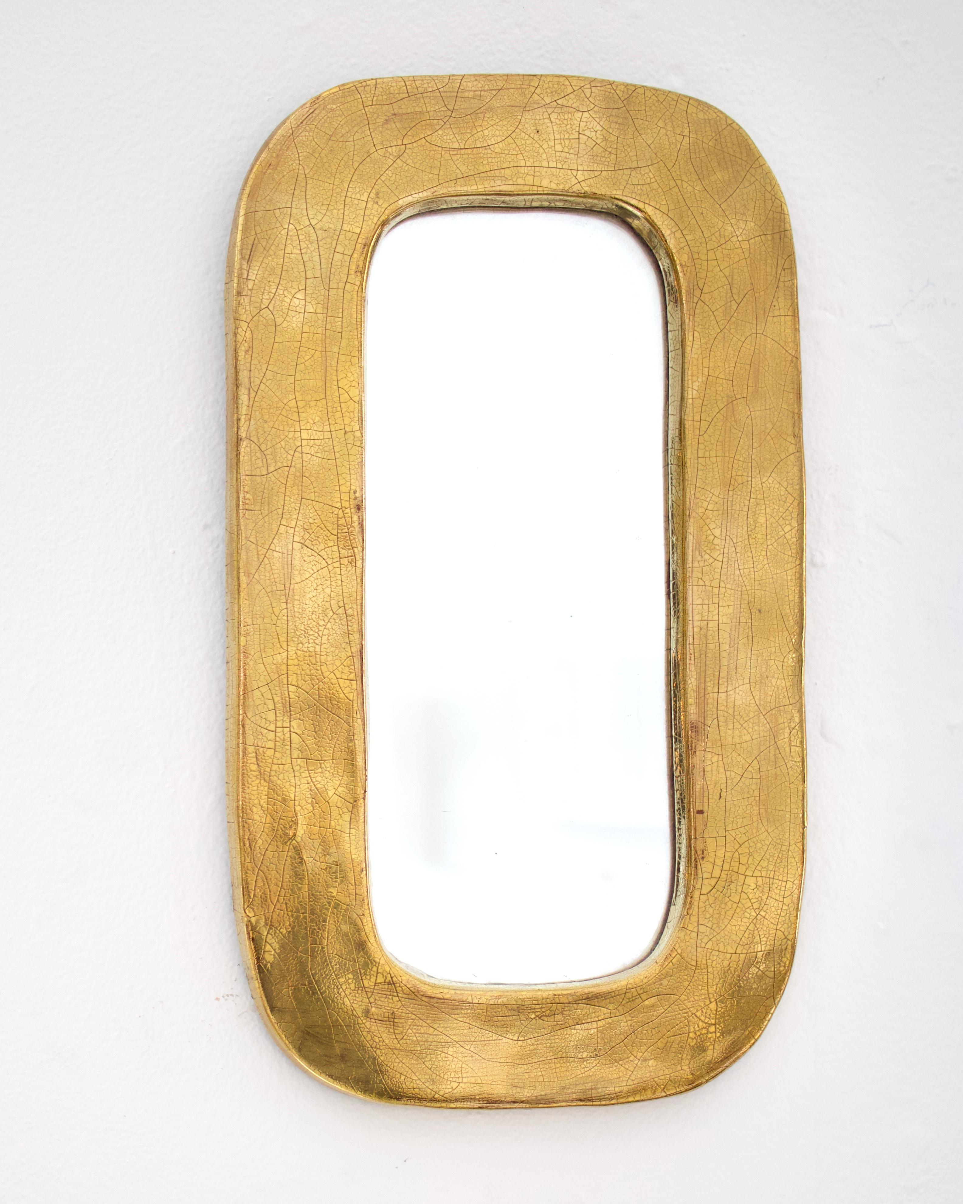 Miroir Mithé Espelt fait à la main avec un glaçage craquelé en céramique dorée France, 1970. 
Chaque miroir est une pièce unique.
En très bon état d'origine avec support en feutre.
Le cadre de la céramique mesure 1,75