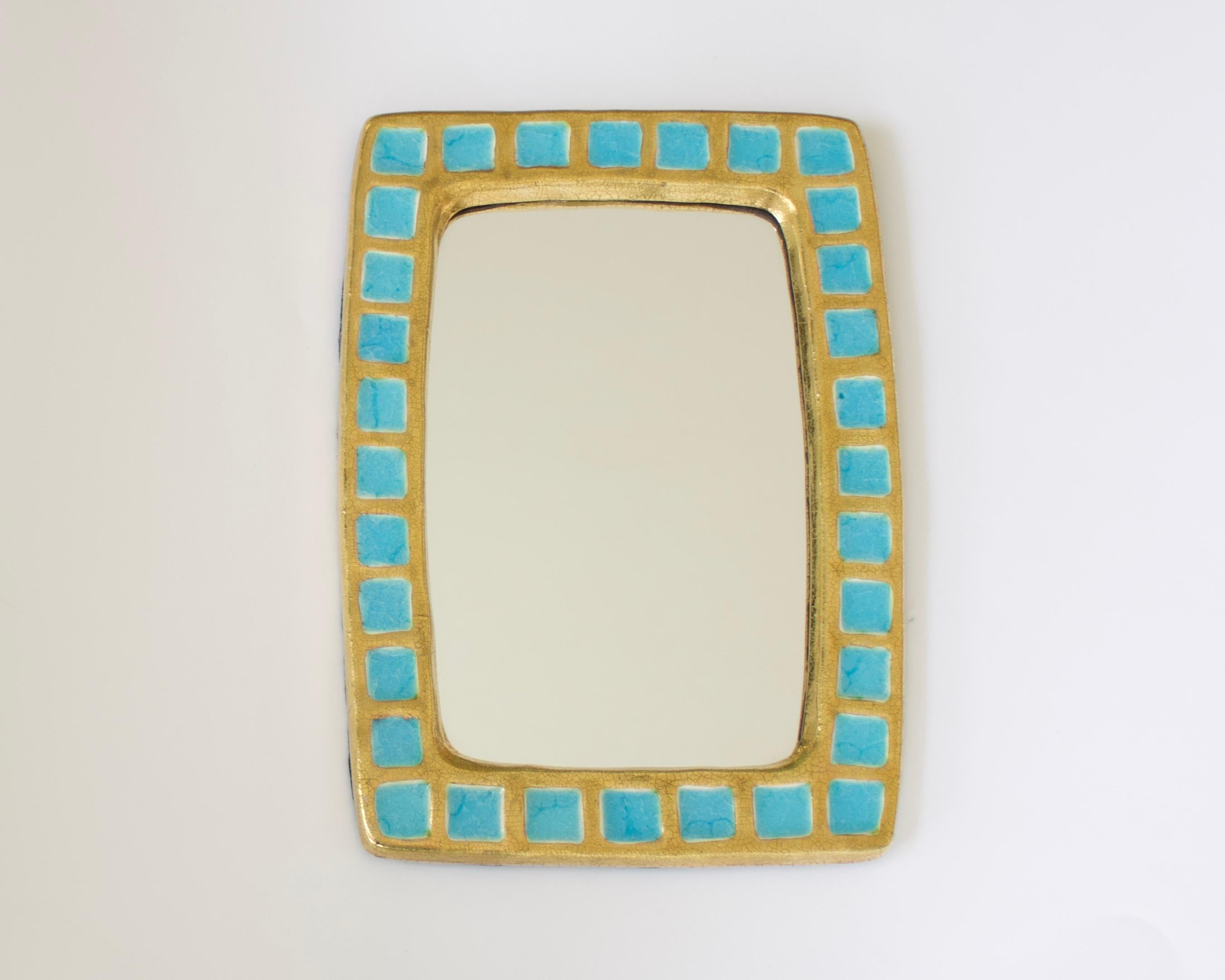 A mirror created by Mithé Espelt, circa 1960, in France. The mirror is composed of tiled fused glass within a gold crackle glazed ceramic frame.
 Very fine original condition.
A similar mirror is pictured on p 111 in the book Mithe Espelt, The