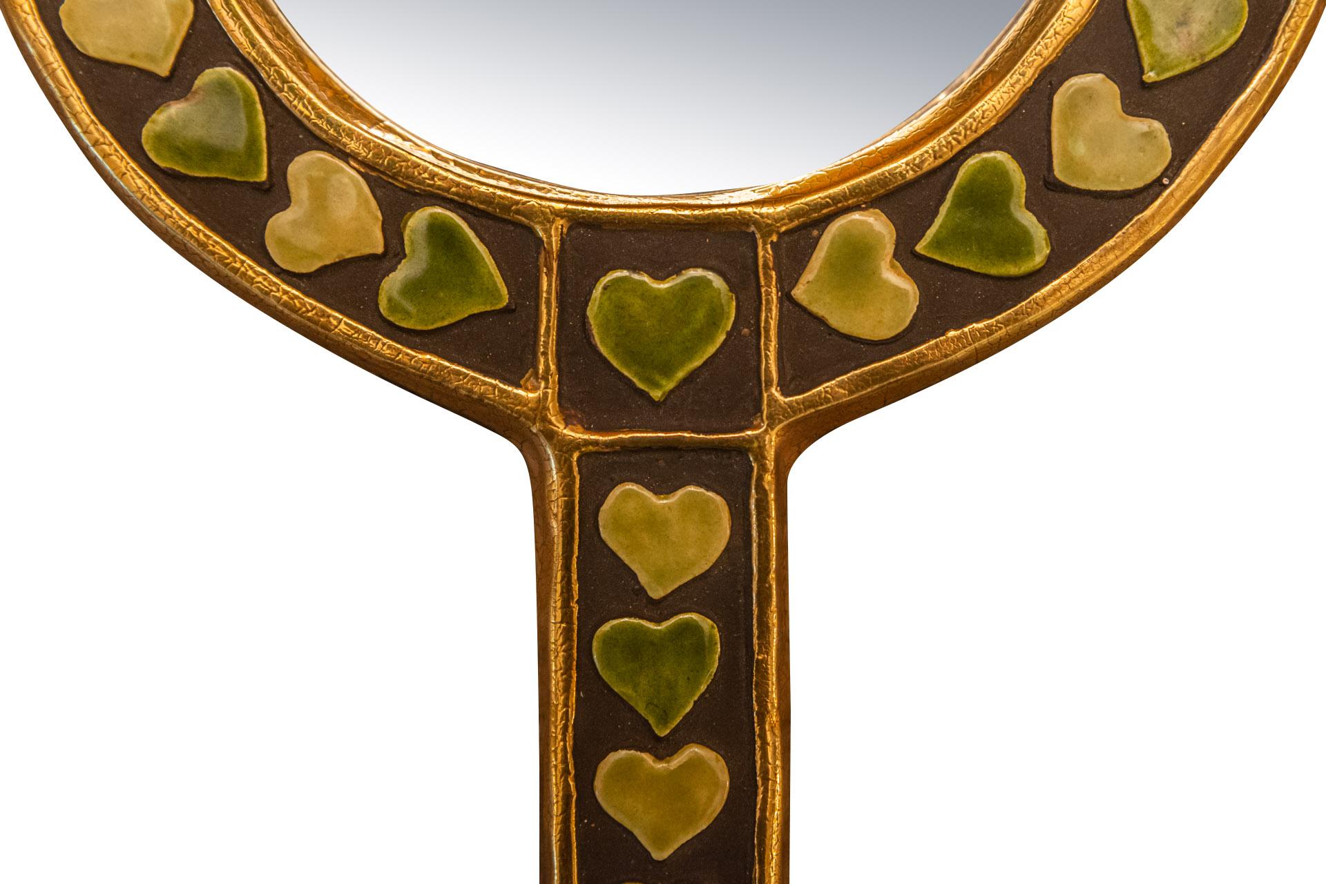 Mithé Espelt (1923-2020-, hand facing mirror, 
Green and gold enameled ceramic decorated with small hearts,
Wrapped in green velvet on the back,
Unsigned,
circa 1960, France. 

Measures : Height 24 cm, diameter 16,5 cm.

Mithé Espelt