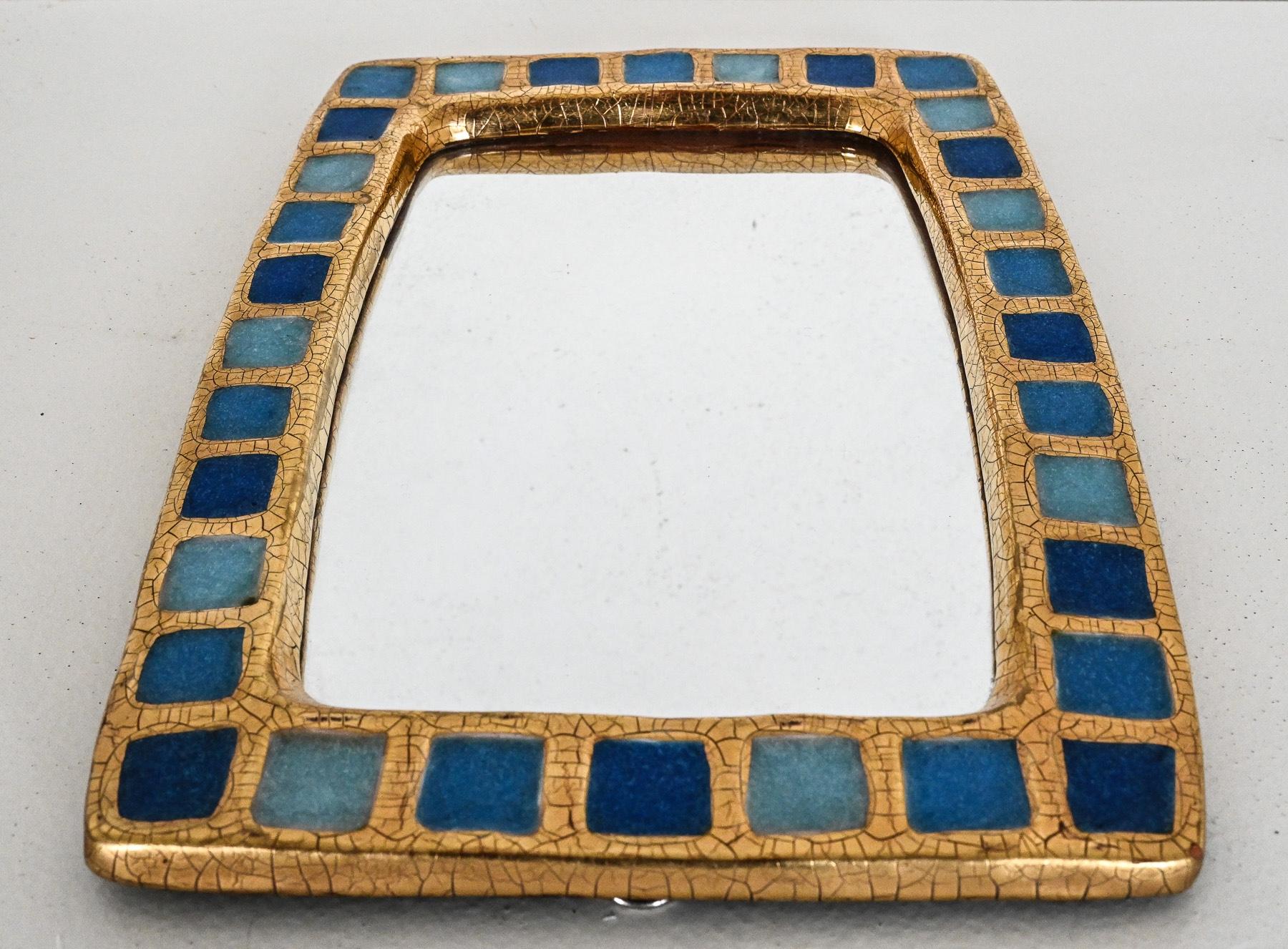 Excellent example of the “Pâte de verre long” mirror c. 1955 by Mithé Espelt
embossed earthenware, crystallised glass in shades of blue and crackled gold. Retains its original green felt backing.
This style of mirror can also be found in