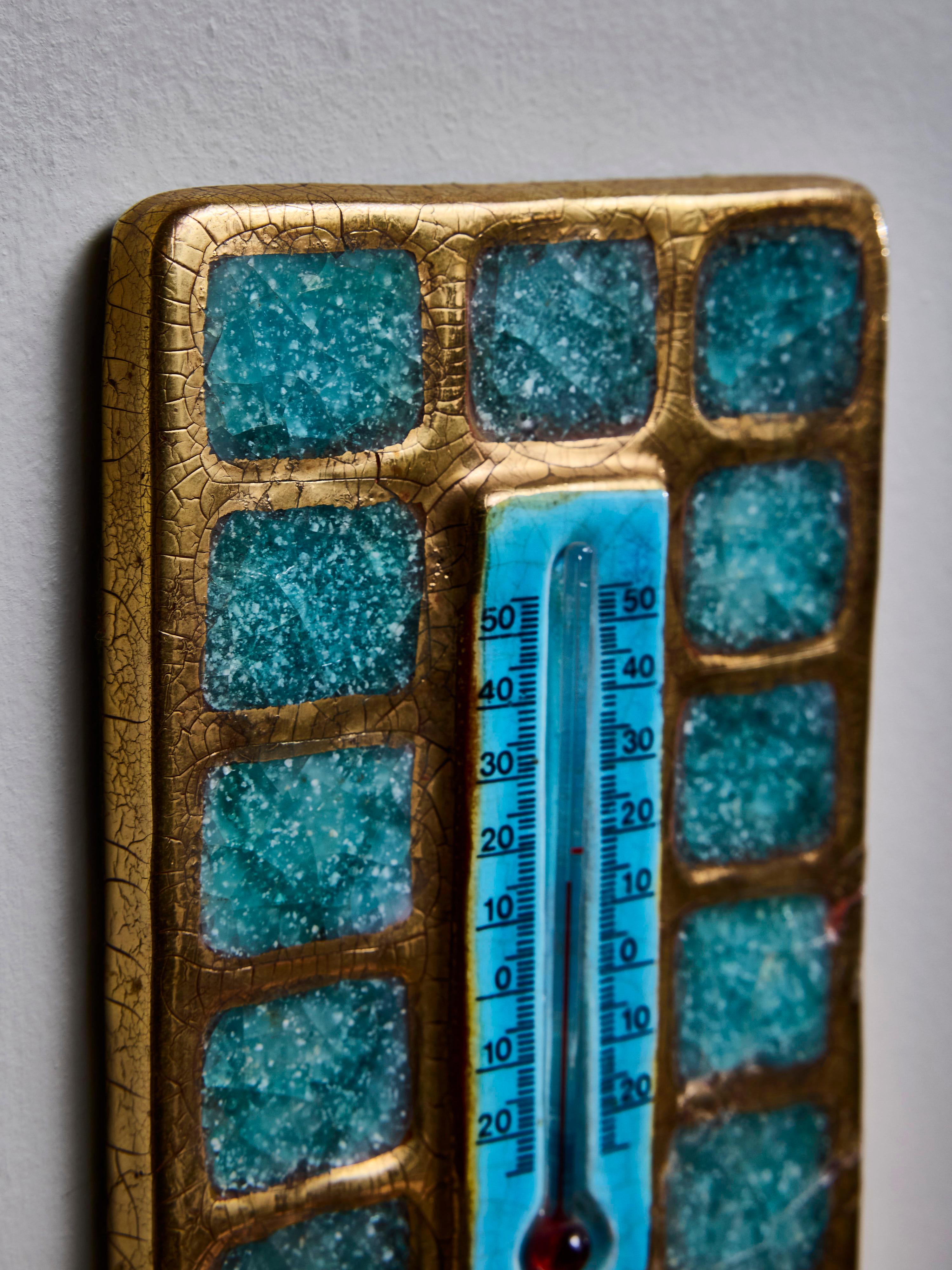 A small decorative thermometer made by Mithé Espelt, featuring a rectangular glazed ceramic frame adorned with squares of blue molten glass.

Marie Thérèse Espelt, aka. Mithé Espelt (1923-2020)

Born in the town of Lunel, near Montpelier; Mithé