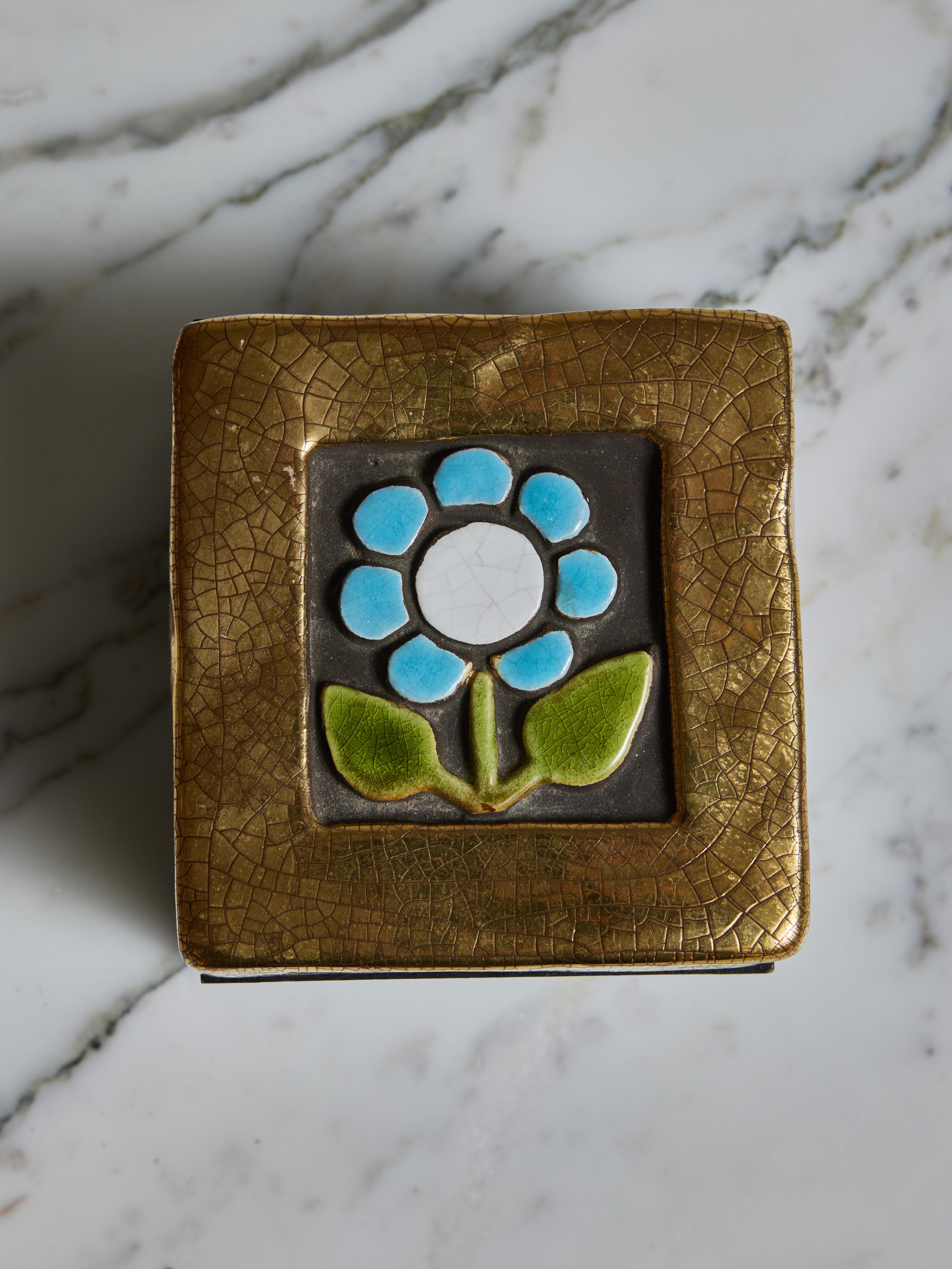 Decorative square box by Mithé Espelt, stained wood box covered with a ceramic lid showing a single white and blue flower framed with gold glaze.

 

Marie Thérèse Espelt, aka. Mithé Espelt (1923-2020)


Born in the town of Lunel, near Montpelier;