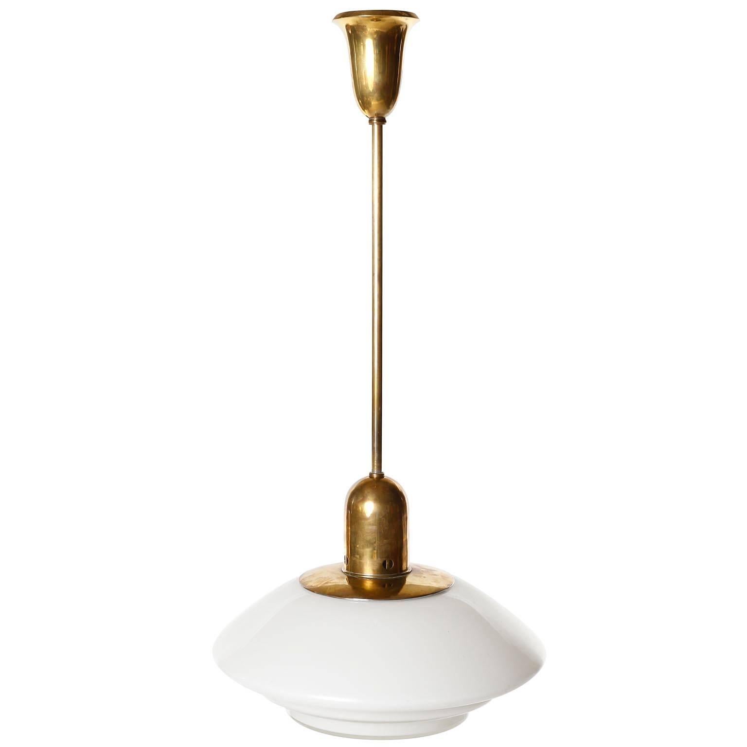 A pendant light model name Mithras, manufactured by August Walther und Söhne (engl. August Walther and Sons), Germany, in 1930s.
An opal white glass lamp shade in stepped form is held by a patinated brass armature and rod.
Cleaned, newly rewired,