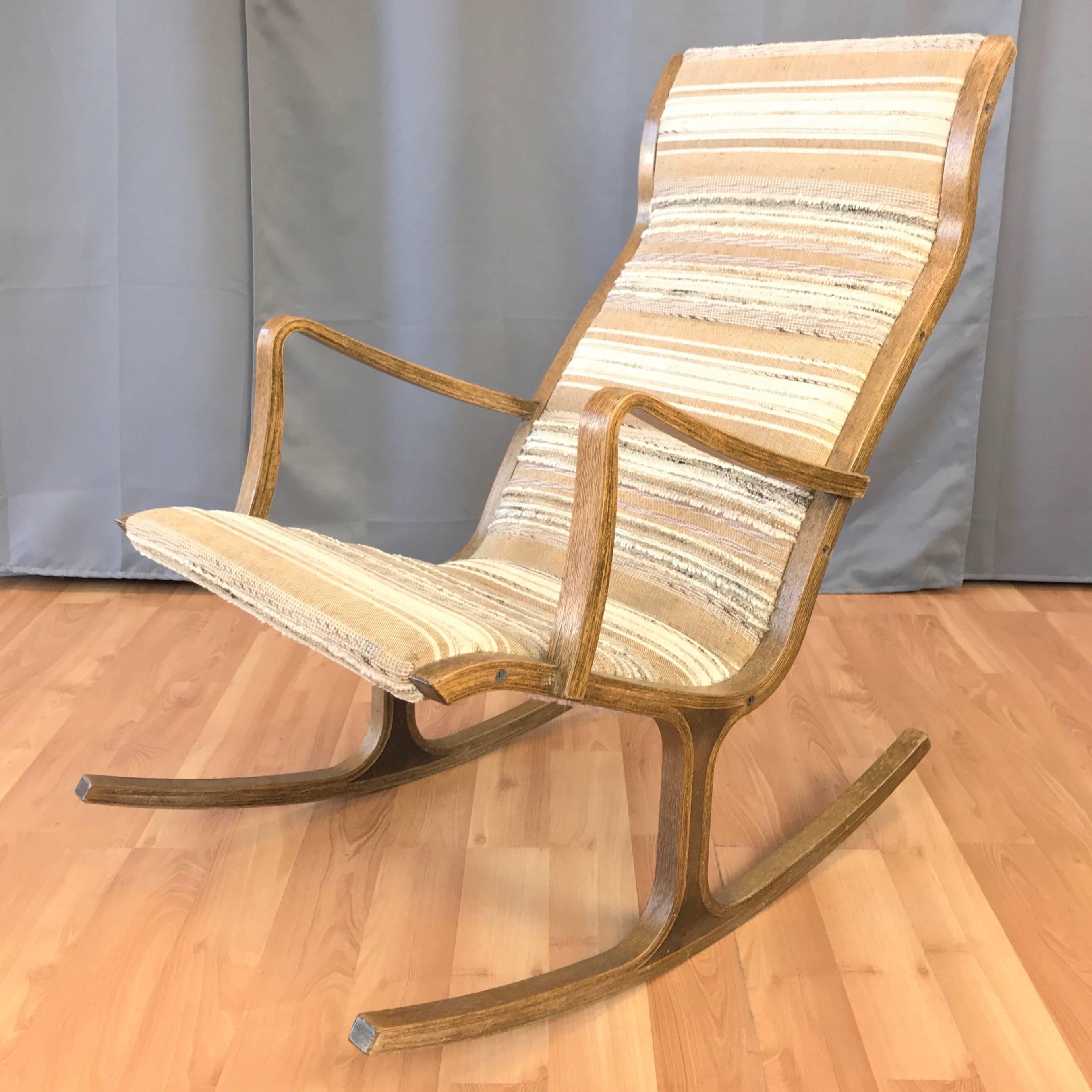 A vintage “Heron” high back oak rocking chair designed in 1966 by Mitsumasa Sugasawa for Tendo Mokko.

Rocker's thin bentwood oak frame references the lithe lines of its namesake. Ergonomic form and low profile padding create a sinuous silhouette