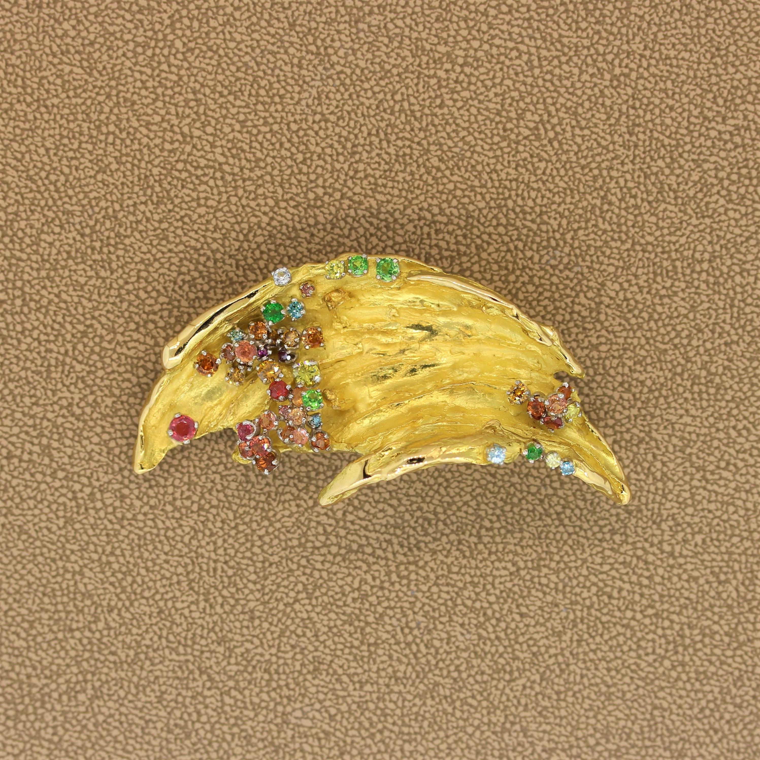 Japanese designer Mitsuo Kaji delivers an exuberant brooch that also doubles as a pendant. The 18K yellow gold leaf form features an array of colors from multi-color gemstones and diamonds which are set in platinum.

Brooch Length: 2.50