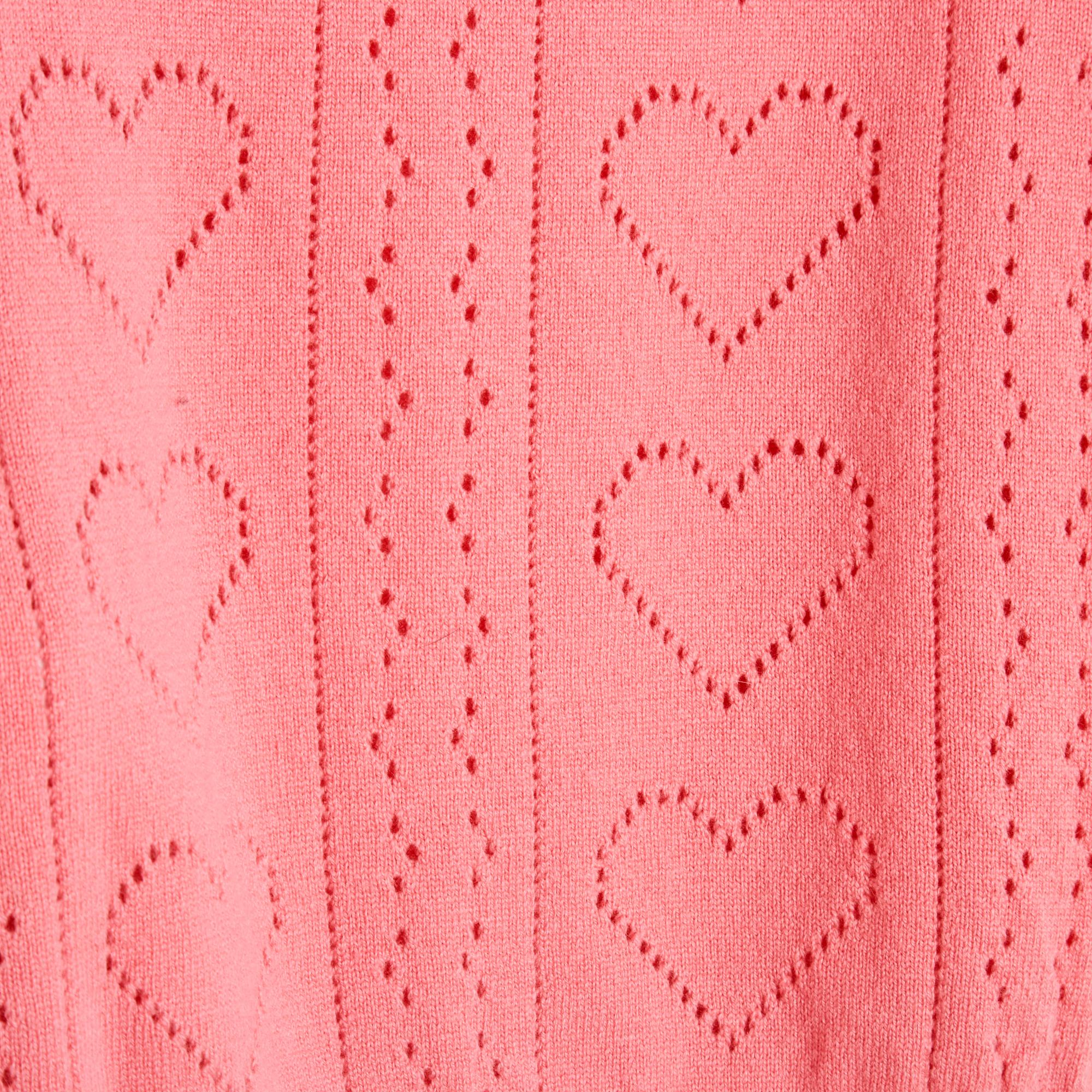 Pull Miu Miu 2015 en cachemire rose, maille cœur ajourée sur le devant, col rond, manches longues, volume cropped, finitions côtelées. Taille 42IT ou 38FR ou UK10 et US6/8 : épaules 40 cm, poitrine 50 cm, longueur 50 cm, manches 63 cm. Le pull est
