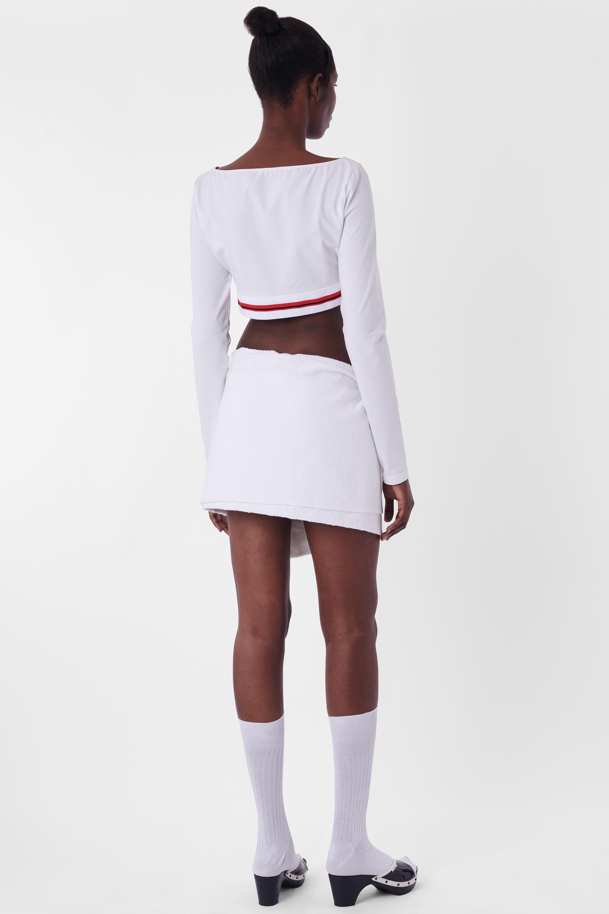 We are excited to present this Miu Miu 2021 Cropped White Top. Features long sleeves, scoop neckline and under bust white and red branded elastic band. In excellent pre loved condition with tags. Authenticity guaranteed.

Label size: Large
Modern