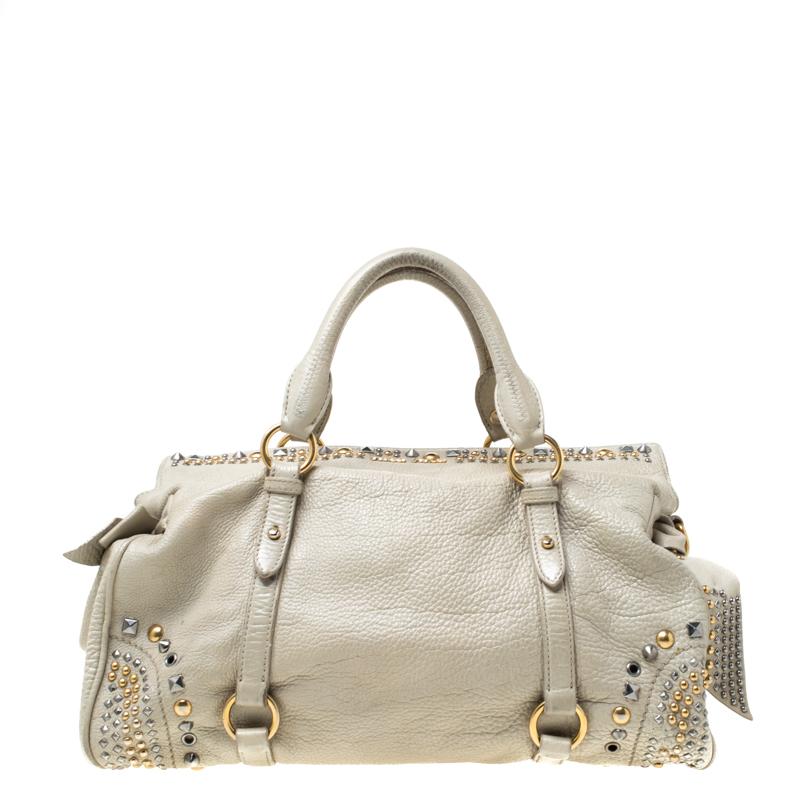 Masterfully crafted in leather, decorated with studs as well as bows and lined with fabric, this satchel from the house of Miu Miu is both stylish and durable. In a lovely shade of beige, this is the perfect pick for your outfit goals!

