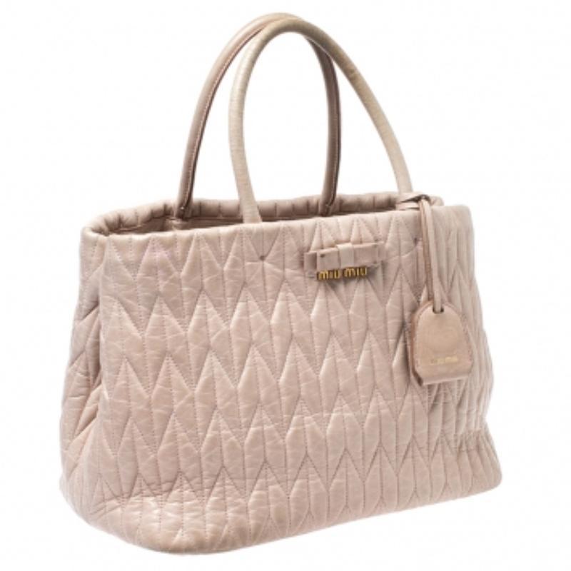 Miu Miu is known for its quality craftsmanship and designs and this bag is no different. Feel great every time you walk out the door with this stunning bag crafted from beige Metalasse leather. It is held by dual handles, a detachable shoulder