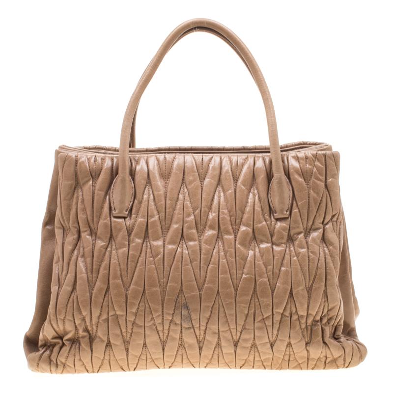 Miu Miu brings us this gorgeous bag that has been crafted from leather and designed with the signature Matelasse pattern all over. It has an understated beige hue and a spacious satin interior capable of carrying your essentials. The piece comes