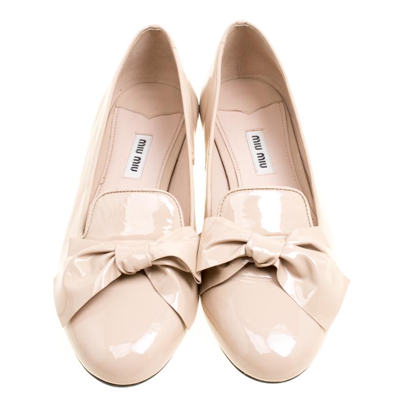 An epitome of comfort and class, these smoking slippers from Miu Miu are designed to add a touch of sophistication to your style. Styled with lovely bows on the uppers, these beige slippers are crafted from patent leather and the heels are detailed