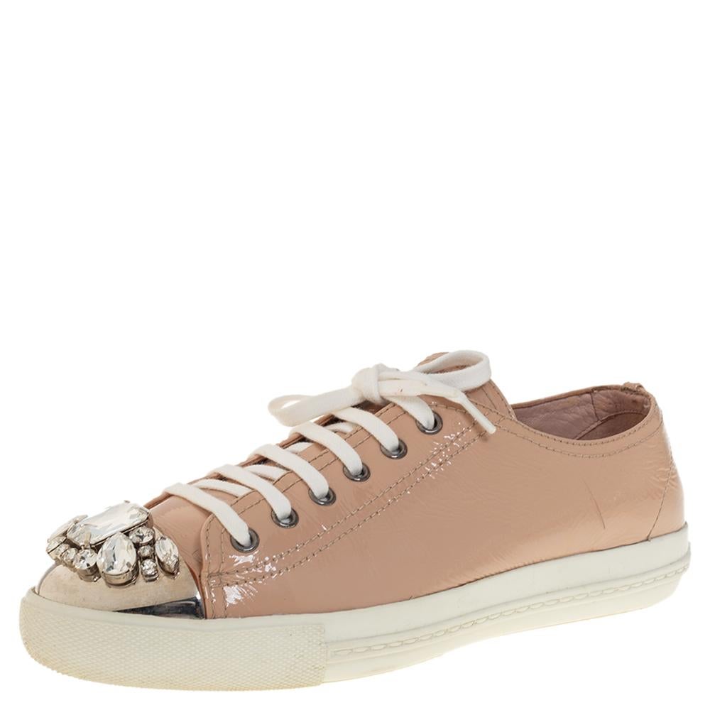 Who says sneakers cannot have a touch of sparkle? These Miu Miu sneakers are brilliantly crafted from patent leather and detailed with lace-ups and crystals on the toes. They are set on comfortable rubber soles and make a great companion to dresses