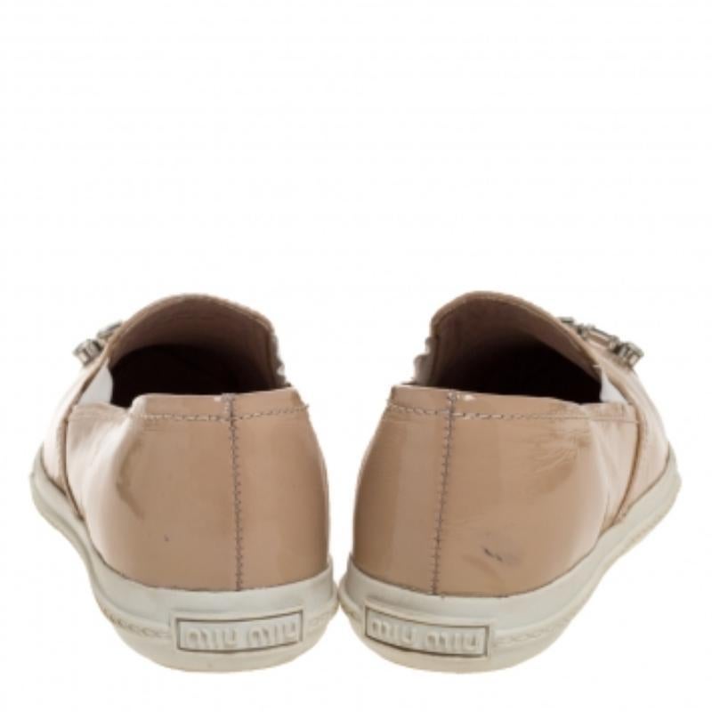 These slip-on sneakers from Miu Miu have been crafted from patent leather and feature pointed cap toes embellished with crystals. They come equipped with comfortable leather-lined insoles and tough rubber soles.