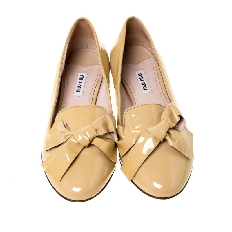 Exquisite and well-made, these Miu Miu loafers are worth owning. They've been crafted from patent leather and they come flaunting a beige shade with bow details on the vamps and stud embellishments on the low heels. The loafers are ideal to be worn