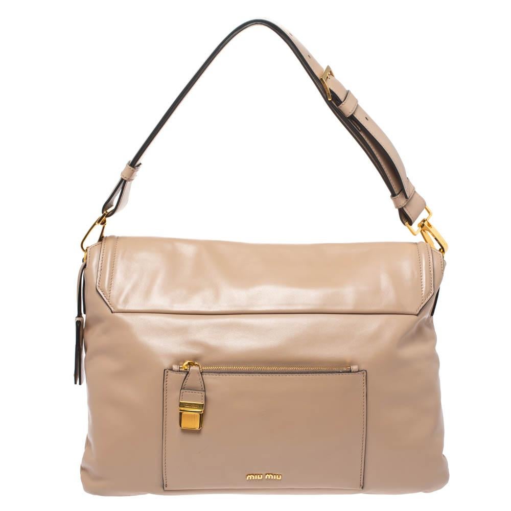 This Miu Miu beauty arrives in a relaxed shape and simple design. Crafted in Italy, it has a leather body in beige, a push lock on the flap and a top handle. The flap secures the fabric interior equipped with a zip pocket and enough space for