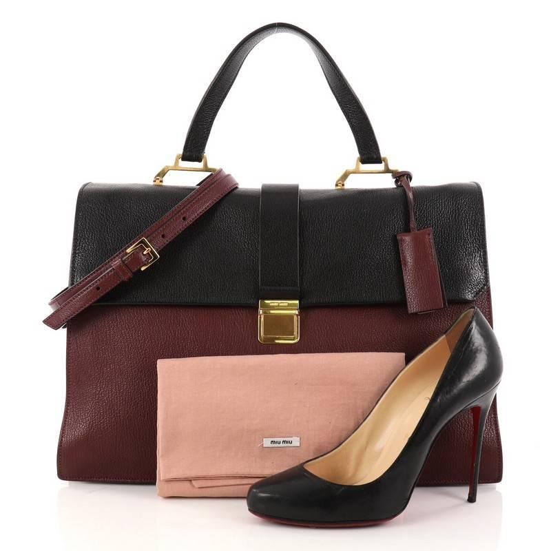 This authentic Miu Miu Bicolor Madras Convertible Compartment Top Handle Bag Leather Large showcases a chic and stylish design perfect for everyday use. Crafted from burgundy and black leather, this sophisticated bag features flat leather top
