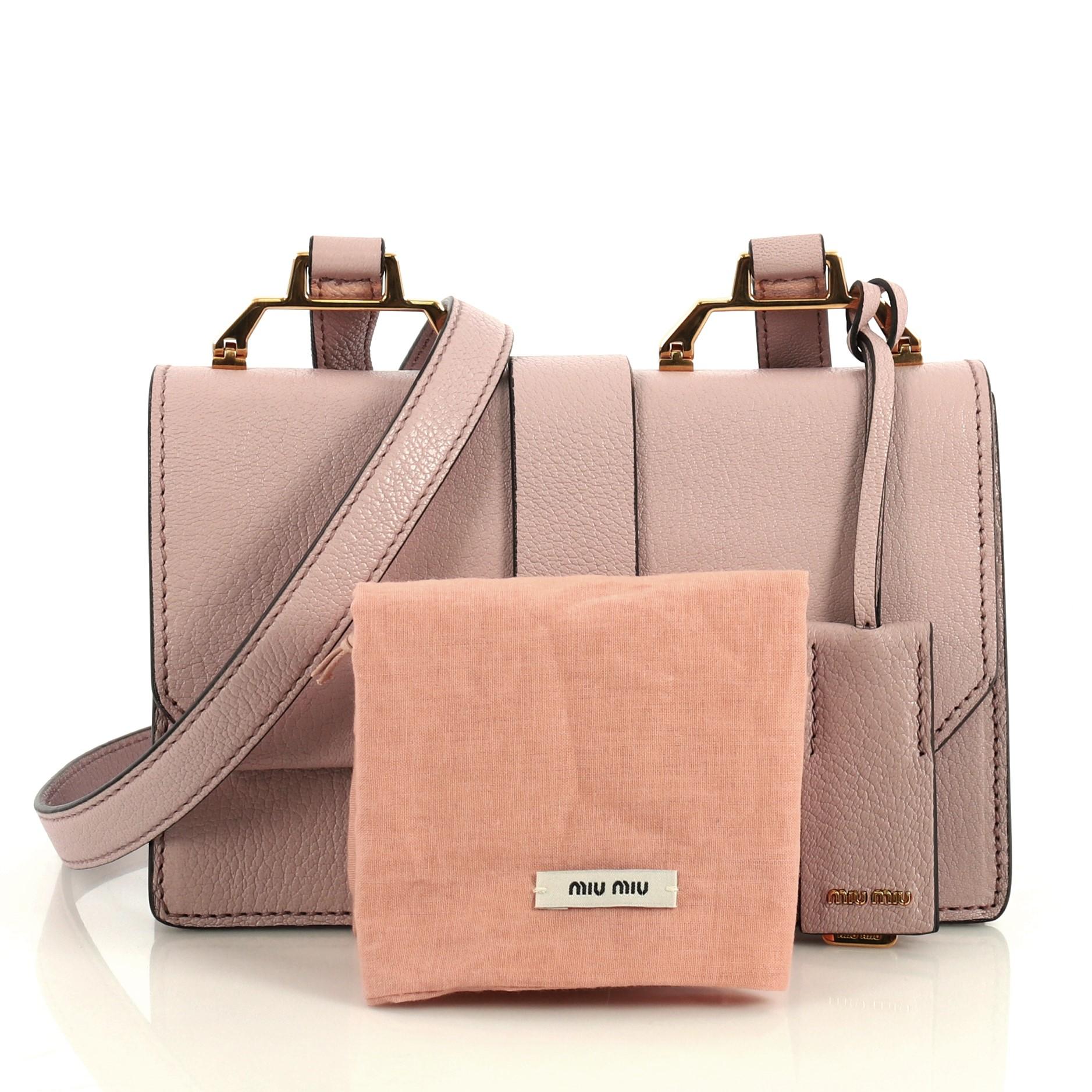 This Miu Miu Bicolor Madras Shoulder Bag Leather Small, crafted from pink leather, features an adjustable shoulder strap, exterior zip pocket and gold-tone hardware. Its push-lock closure opens to a pink suede interior with two open compartments and