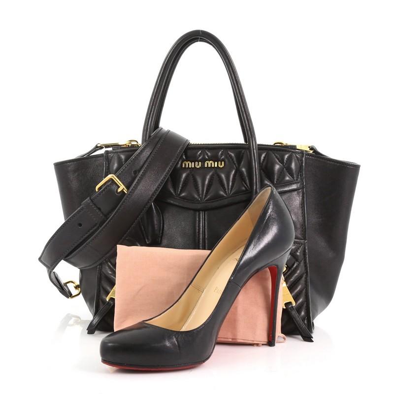 This Miu Miu Biker Convertible Tote Leather Small, crafted from black leather, features dual rolled handles, exterior front zip pockets, two zip compartments, and gold-tone hardware. Its magnetic snap closure opens to a black leather interior with