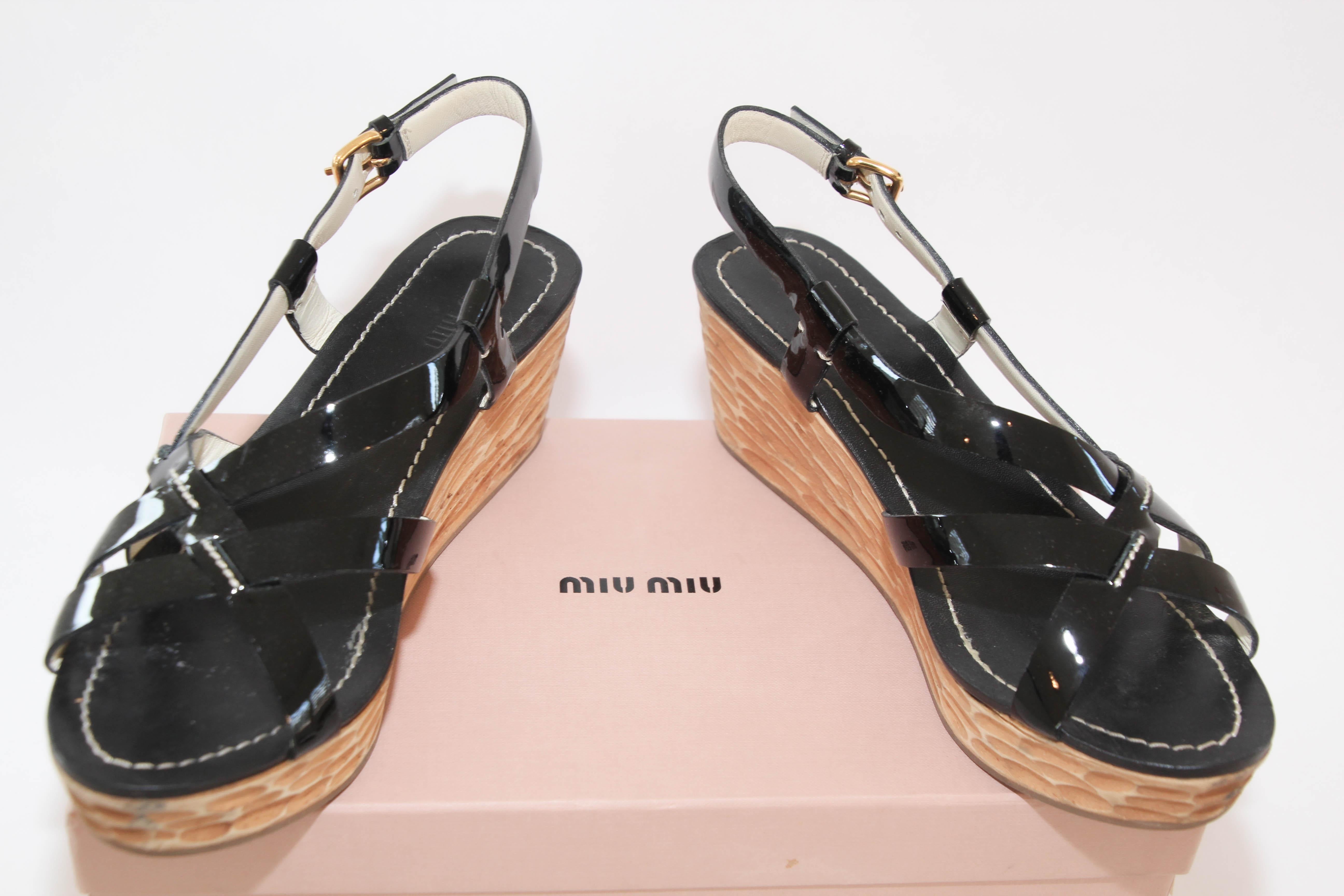 Miu Miu Black Criss Cross Patent Leather Sling Back Wooden Wedges Sandals Size 38.
MIU MIU black patent leather sandals, slingback, wedge heels with platform, crossover stripes with brass buckle closure at ankles.
Flaunt style at its best with these