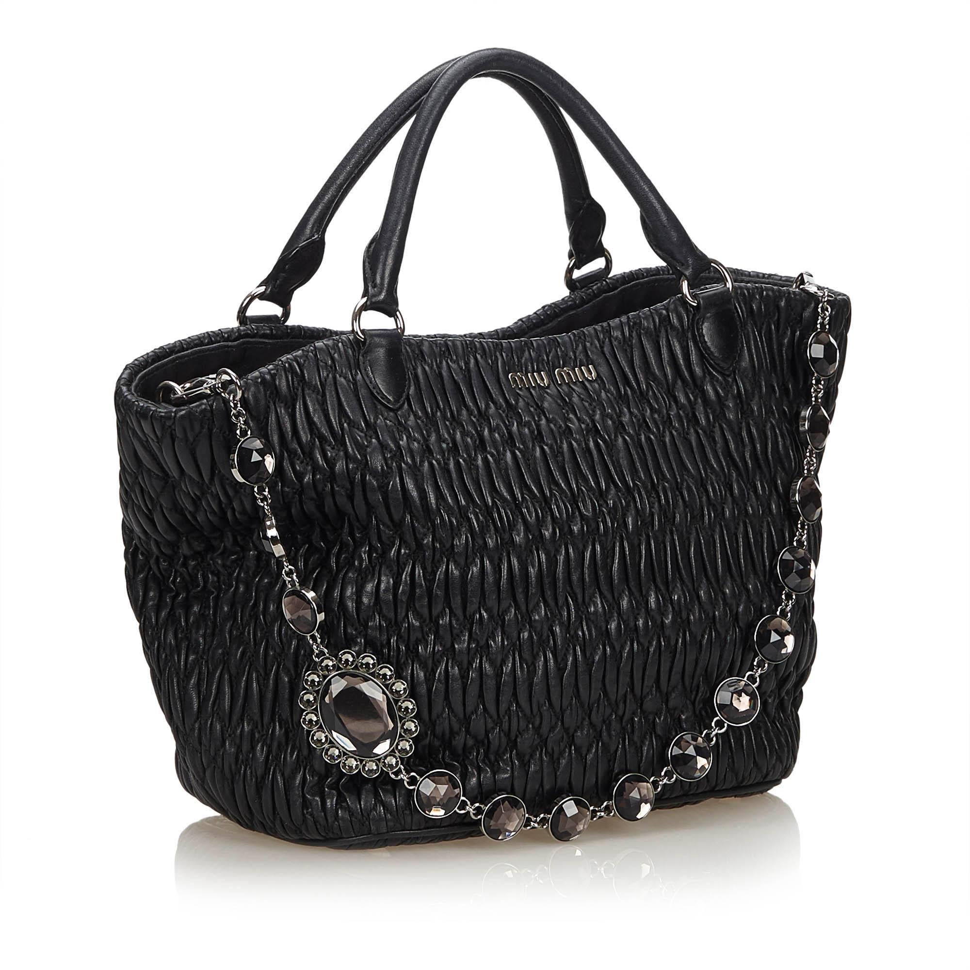 This bag features a gathered leather body, rolled leather handles, crystal embellished chain strap, clasp closure, and interior zip and slip pocket. It carries as AB condition rating.

Inclusions: 
This item does not come with