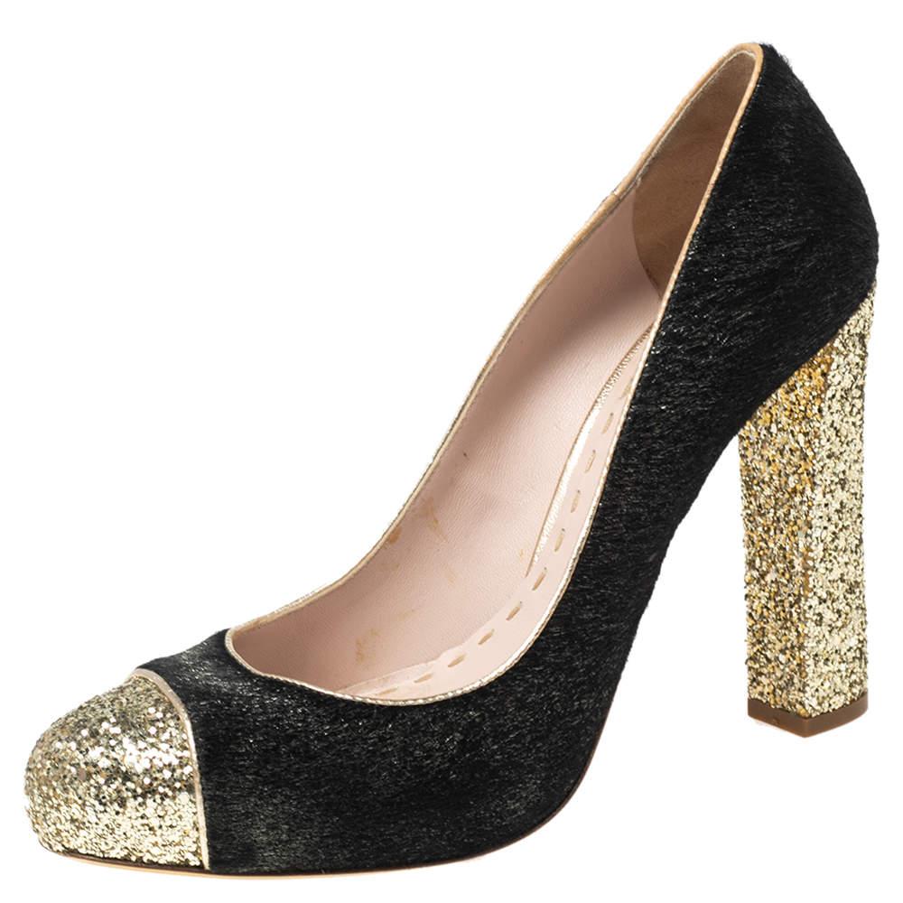 Ces escarpins de Miu Miu sortent tout droit du rêve d'une amoureuse de la chaussure. Confectionnées en poils de veau, elles présentent des orteils à capuchon pailleté, des plateformes dissimulées et des talons bloc à paillettes. Les escarpins