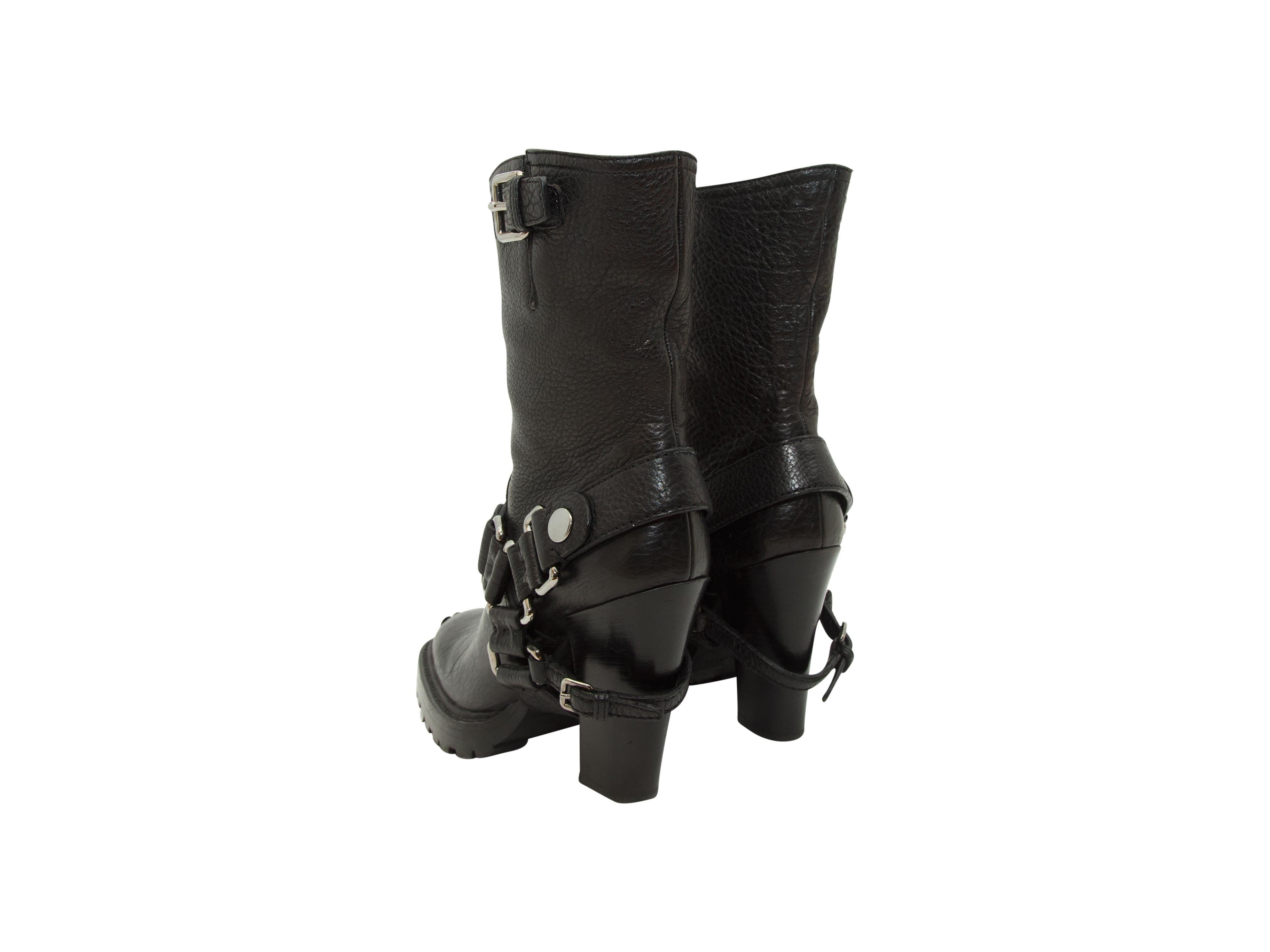 Product details:  Black leather high heel moto-style ankle boots by Miu Miu.  The black leather ankle boots have silver hardware on the toe and top of the boot, and on the black leather boot strap.  Round toe.  4.5