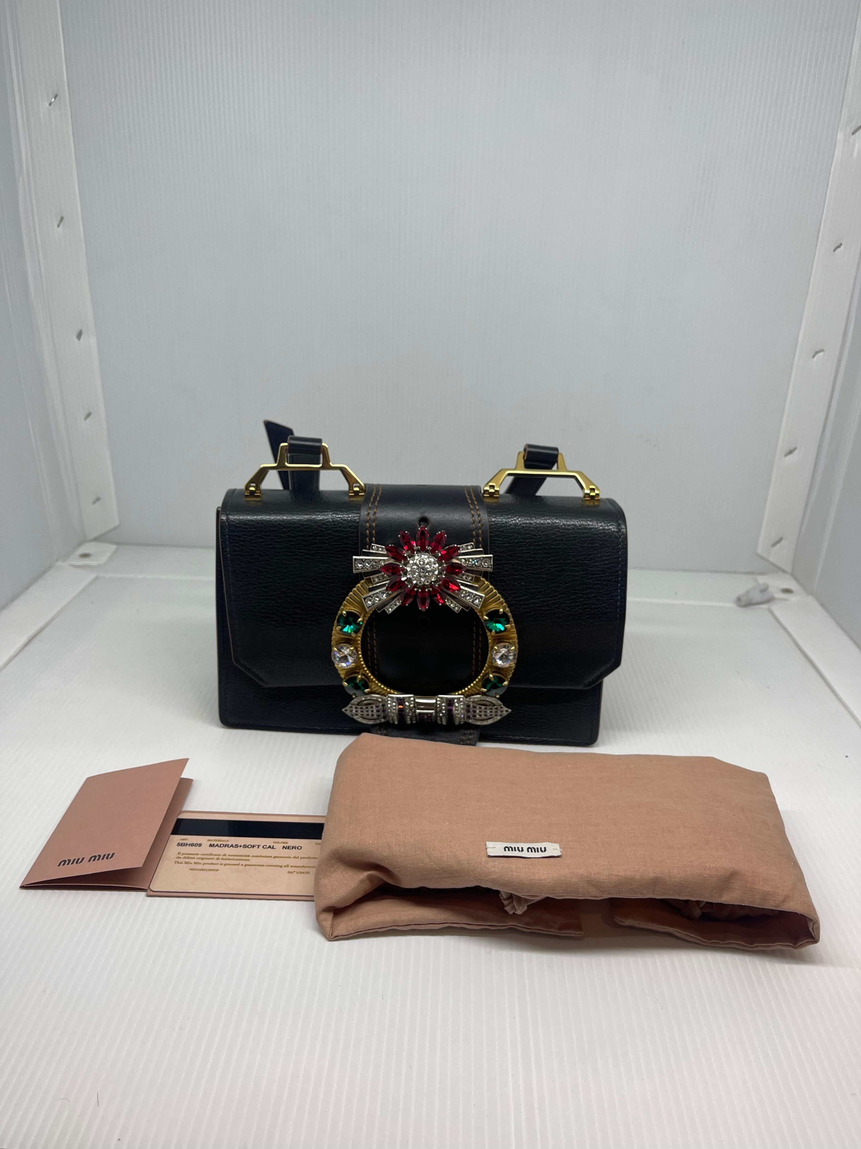 Miu miu madras jewel embellished crossbody bag in black leather. Overall still in great condition, faint scratches on the leather surface as seen on pictures and faint tarnishing on the embellishments. Suede lining shows minor rubbing. Comes with
