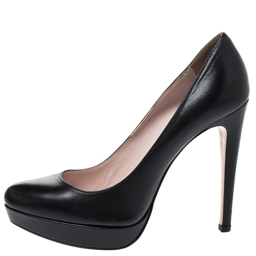 Adorn your feet with this adorable pair of platform pumps by Miu Miu. Boasting a black leather exterior, they feature round toes, high stiletto heels and supporting platforms. The insoles are leather-lined and carry brand detailing. These pumps will