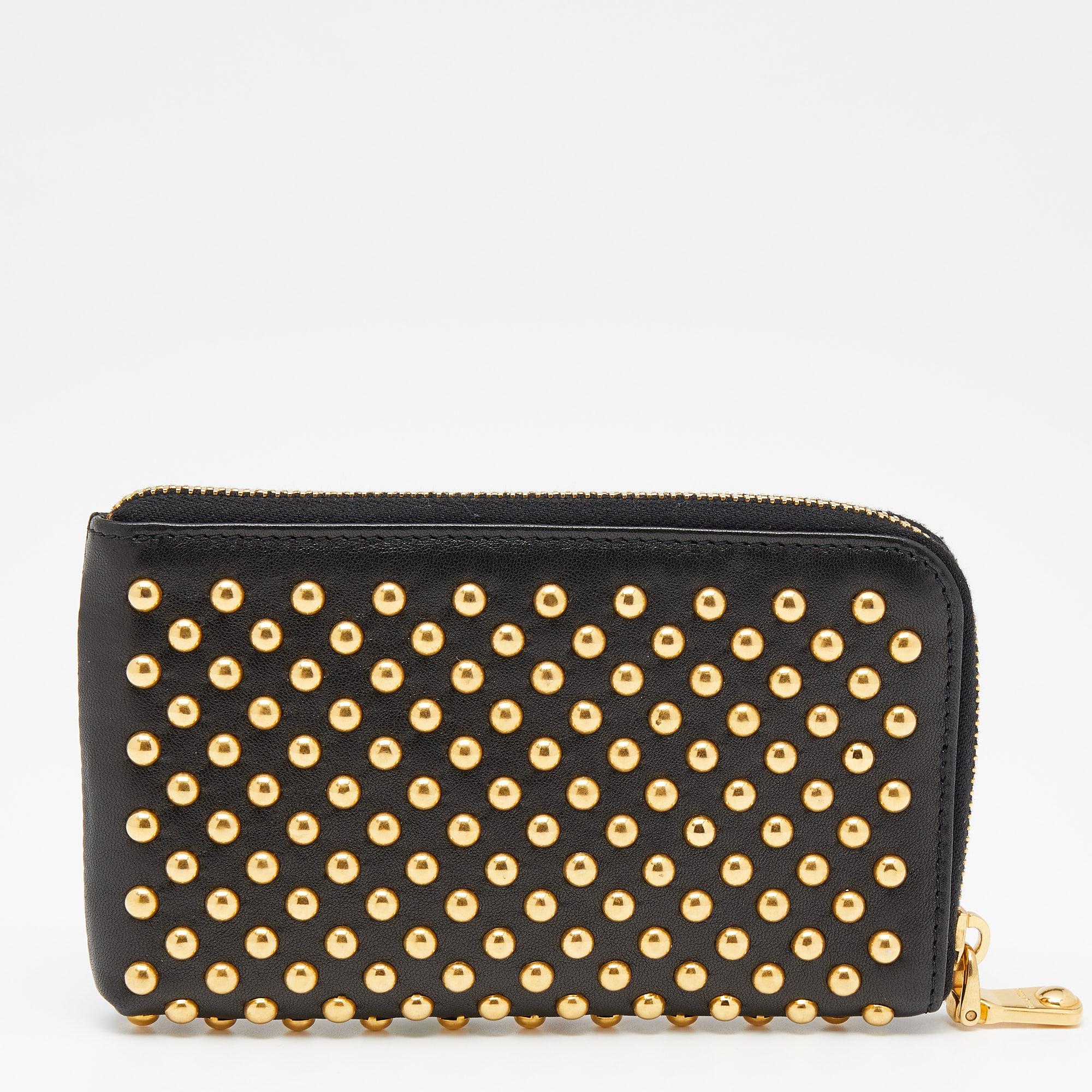 Give your essentials a stylish home with this studded wallet from the house of Miu Miu. Durable and long-lasting, this wallet is crafted from leather. A classic black shade and a zip closure characterize this fine wallet.

