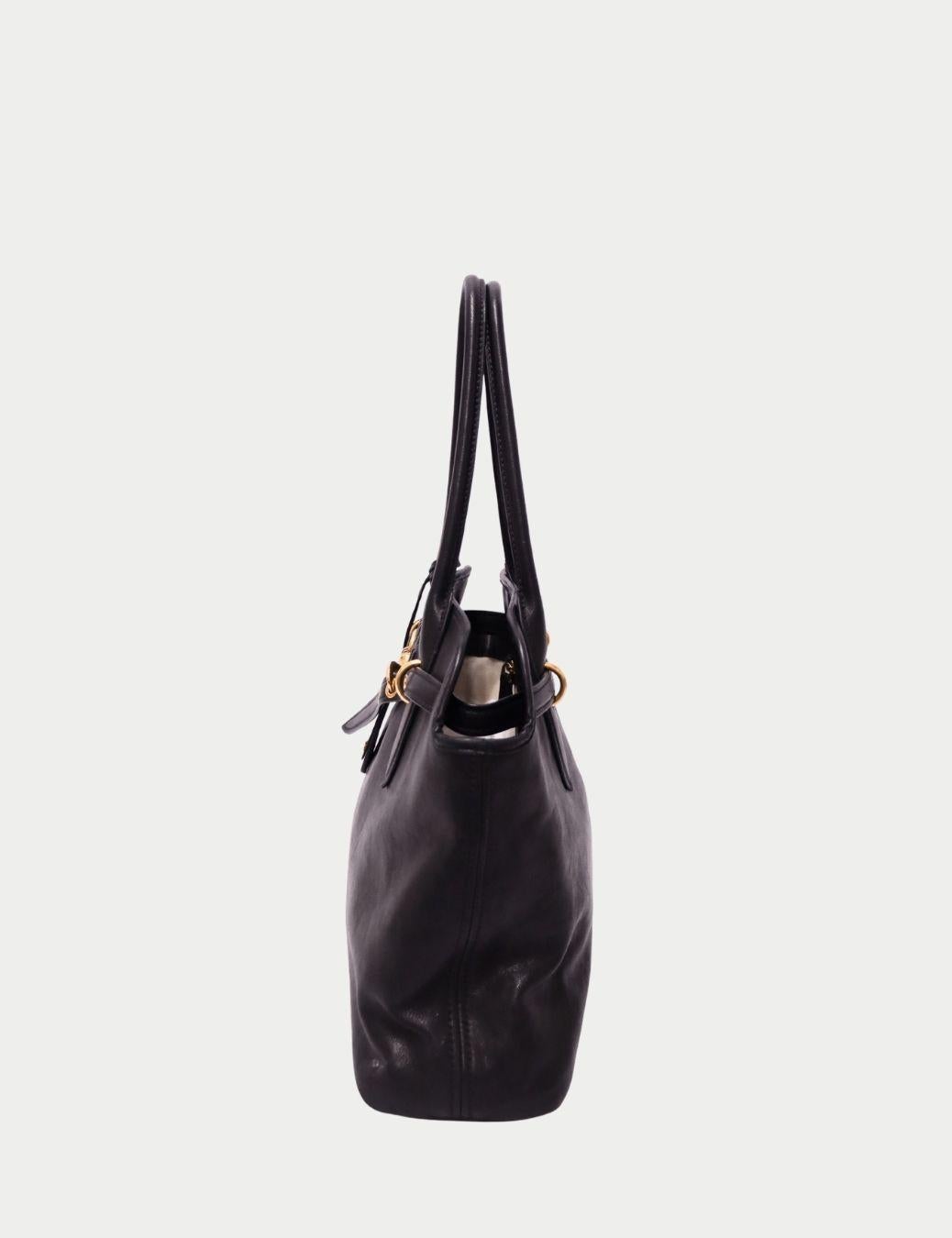 Miu Miu Bolso Tote de Piel Negro con Herrajes Dorados

Aporta un toque chic italiano a tu vestuario diario con este bolso tote de piel negra de Miu Miu, confeccionado en suave piel de alta calidad y acentuado con elegantes herrajes dorados. Diseñada