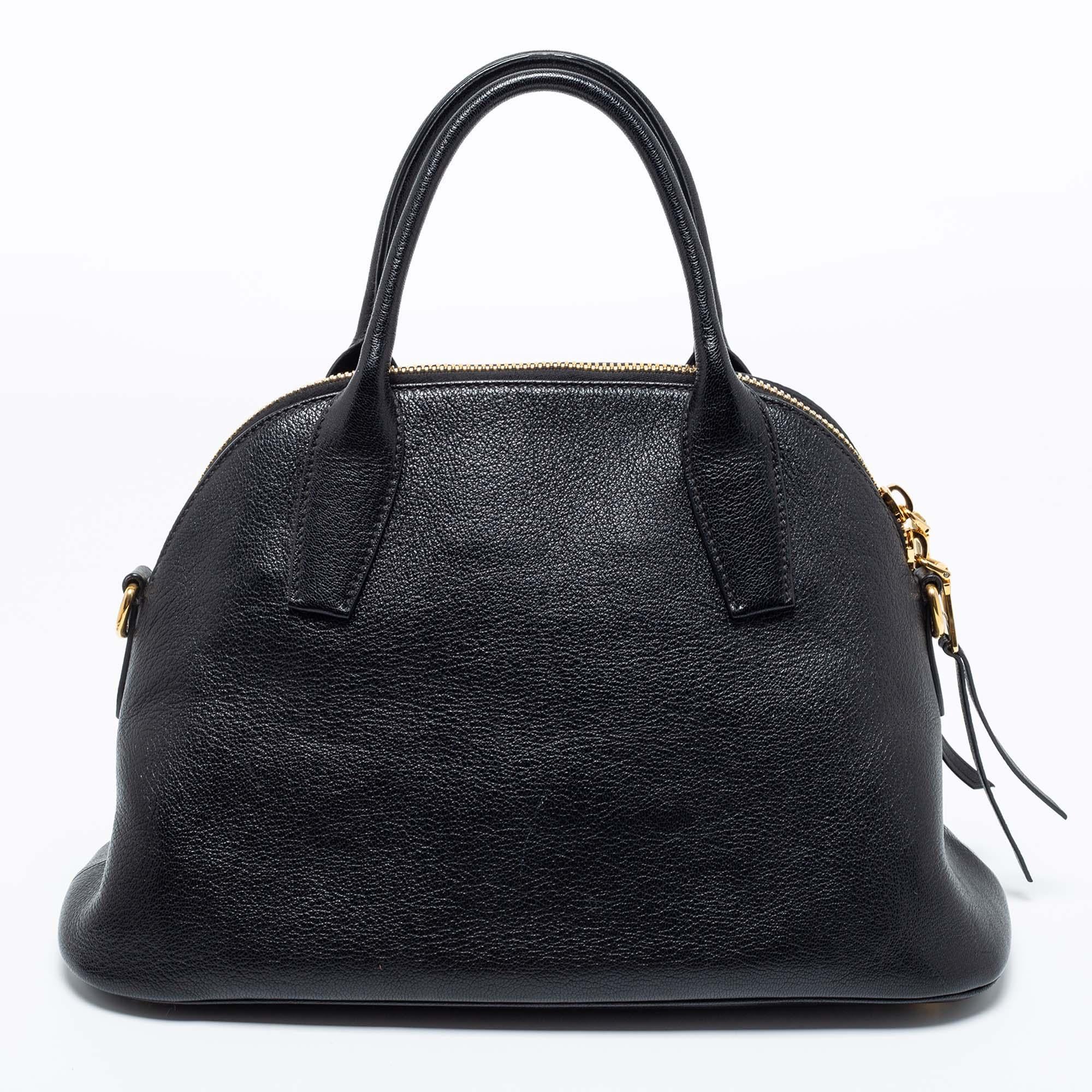Simple and classy, style your outfit with this black satchel from Miu Miu. Crafted from Madras leather, the bag is held by dual handles and a shoulder strap. The double zip closure opens to a leather-lined interior that can hold all your essentials