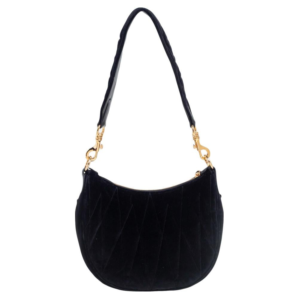 This lovely shoulder bag is from Miu Miu. Meticulously crafted using Matelassé velvet, it comes in a shade of black. It has a shoulder strap and a satin-lined interior. The creation is finished with gold-tone hardware.

Includes: Original Dustbag,