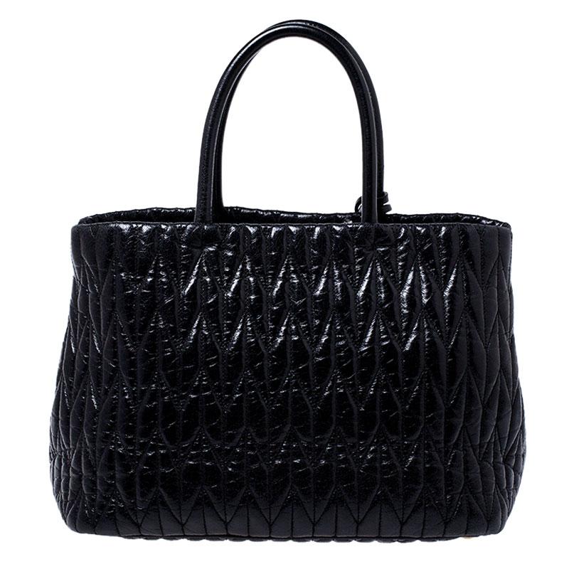 Feel great every time you walk out the door with this well-made leather bag. With the interior lined in satin, this bag is spacious and stylish. This admirable Miu Miu tote in black is held by two handles and finished with the brand name on the