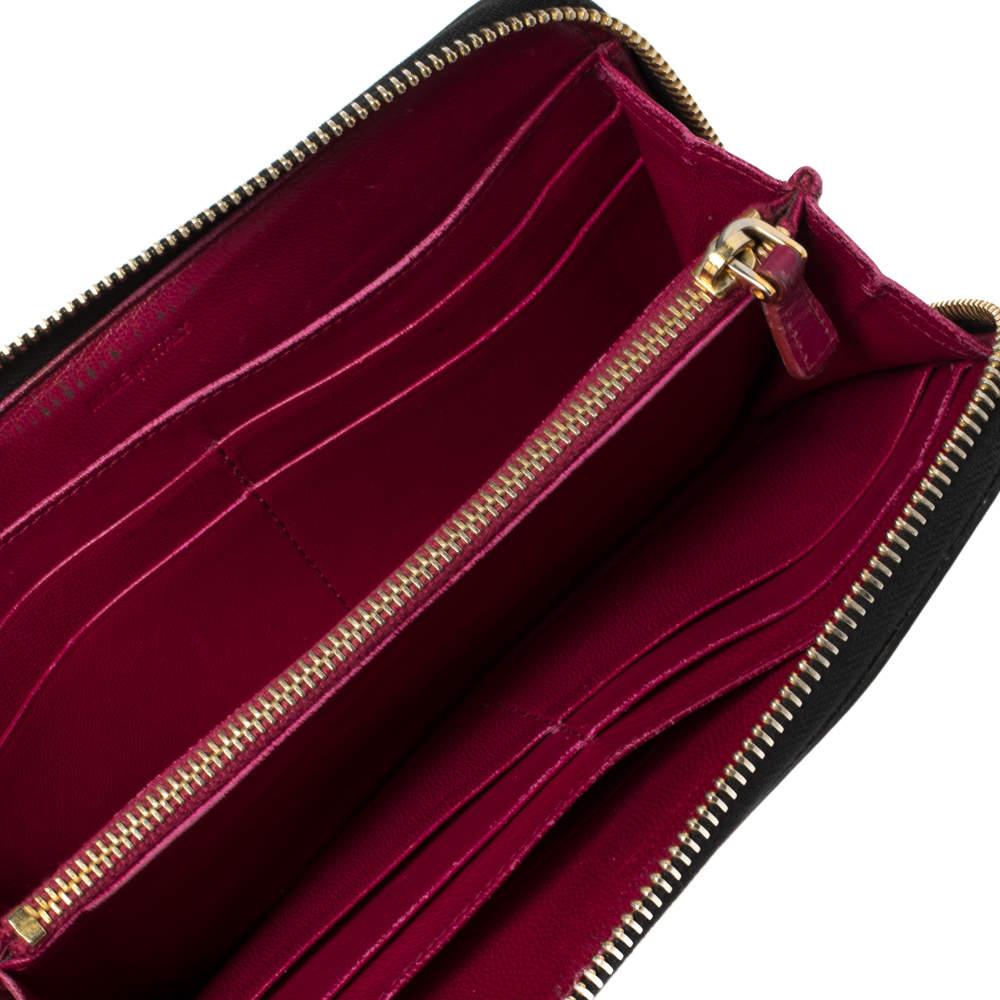 Crafted from patent leather, this Miu Miu wallet is a piece of perfection. Its black exterior is coupled with gold-tone hardware, the signature logo at the back and on the front, a wide bow adds interest. Lined with leather & fabric, it has an