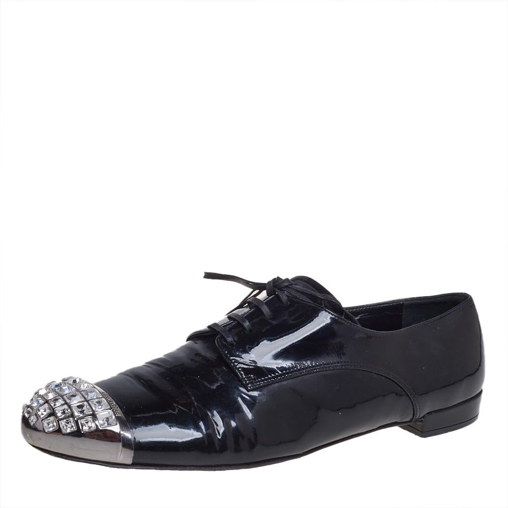 To perfectly complement your attires, Miu Miu brings you this pair of oxfords that speak nothing but style. They have been crafted from black patent leather and styled with crystal-embellished cap toes and lace-ups on the vamps. They are endowed